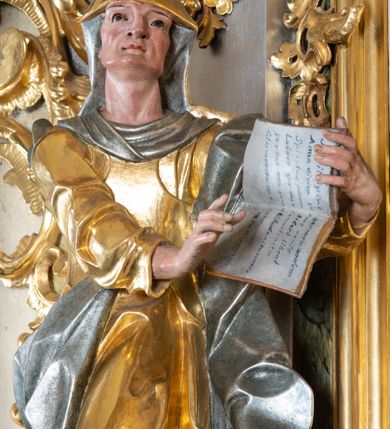 Zdjęcie nr 8: Ołtarz przyścienny, architektoniczny z mensą w formie sarkofagu o wklęsło-wypukłych bokach. W mensie kamienny portatyl. Retabulum jednoosiowe, jednokondygnacyjne ze zwieńczeniem, ustawione na wysokim zdwojonym cokole, zryzalitowanym bo bokach. Nastawa ujęta parą narożnych pilastrów kompozytowych oraz parą kolumn znacznie wysuniętych przed lico ołtarza. Kolumny o kanelowanych trzonach i kompozytowych głowicach podtrzymują faliste belkowanie. Zwieńczenie ujęte po bokach motywami „S” kształtnymi o wolutowo zwiniętych końcach, z których dolne mocno wysunięte do przodu, spoczywają na belkowaniu. Zwieńczenie zamknięte dwoma stykającymi się wolutami. Po bokach retabulum ażurowe uszaki formowane z grzebieni rocaille'owych i motywów „C” kształtnych z rzeźbioną, uskrzydloną główką anielską. 
Pole środkowe w kształcie prostokątnej wnęki z zamknięciem kształtowanym z motywów „C”. We wnęce płaskorzeźba z przedstawieniem Najświętszej Marii Panny Niepokalanie Poczętej ujęta podwójną profilowaną ramą. U dołu, po bokach wnęki dwie konsole z ustawionymi pełnoplastycznymi figurami św. Elżbiety po prawej oraz św. Anny po lewej stronie. Święta Elżbieta trzyma kartę z napisem: „IOANNES / EST / NOMEN / EIUS / Ann(…)”, a święta Anna otwartą księgę zapisaną słowami: „Merito igitur / germen eadem / Anaa divino germo reult / Spiritus pierna liberi libent / Labori qve durionustructa / Vertat am sancti ludaribusmais / Clamorite me cum opta / veram”. Ponad kolumnami, po bokach zwieńczenia dwie figury aniołów, powyżej para uskrzydlonych puttów. W zwieńczeniu owalna wnęka z obrazem przedstawiającym św. Jana Chrzciciela, ujętym podwójną ramą. 
Ołtarz bogato dekorowany. Mensa zdobiona ornamentem rocaille'owym. Pola cokołów zdobione płycinami kształtowanymi z grzebieni rocaille'owych dekorujących też fryz. Trzony kolumn i pilastrów zdobią podwieszane motywy rocaille'owe przeplatane z gałązkami róż, tworzącymi również rozległy, ażurowy kartusz nad polem środkowym. Boki zwieńczenia ujęte ażurowymi liśćmi akantu. Poniżej wnęki ażurowa, ukośna kratka regencyjna. Boki wnęki i szczyt zwieńczenia dekorowane pełnoplastycznymi rocaille'ami. 
Całość struktury ołtarza pokryta malowaną marmoryzacją w odcieniach zieleni i brązu. Detal architektoniczny złocony, pilastry srebrzone.