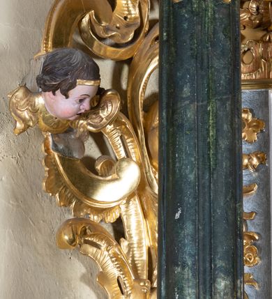 Zdjęcie nr 21: Ołtarz przyścienny, architektoniczny z mensą w formie sarkofagu o wklęsło-wypukłych bokach. W mensie kamienny portatyl. Retabulum jednoosiowe, jednokondygnacyjne ze zwieńczeniem, ustawione na wysokim zdwojonym cokole, zryzalitowanym bo bokach. Nastawa ujęta parą narożnych pilastrów kompozytowych oraz parą kolumn znacznie wysuniętych przed lico ołtarza. Kolumny o kanelowanych trzonach i kompozytowych głowicach podtrzymują faliste belkowanie. Zwieńczenie ujęte po bokach motywami „S” kształtnymi o wolutowo zwiniętych końcach, z których dolne mocno wysunięte do przodu, spoczywają na belkowaniu. Zwieńczenie zamknięte dwoma stykającymi się wolutami. Po bokach retabulum ażurowe uszaki formowane z grzebieni rocaille'owych i motywów „C” kształtnych z rzeźbioną, uskrzydloną główką anielską. 
Pole środkowe w kształcie prostokątnej wnęki z zamknięciem kształtowanym z motywów „C”. We wnęce płaskorzeźba z przedstawieniem Najświętszej Marii Panny Niepokalanie Poczętej ujęta podwójną profilowaną ramą. U dołu, po bokach wnęki dwie konsole z ustawionymi pełnoplastycznymi figurami św. Elżbiety po prawej oraz św. Anny po lewej stronie. Święta Elżbieta trzyma kartę z napisem: „IOANNES / EST / NOMEN / EIUS / Ann(…)”, a święta Anna otwartą księgę zapisaną słowami: „Merito igitur / germen eadem / Anaa divino germo reult / Spiritus pierna liberi libent / Labori qve durionustructa / Vertat am sancti ludaribusmais / Clamorite me cum opta / veram”. Ponad kolumnami, po bokach zwieńczenia dwie figury aniołów, powyżej para uskrzydlonych puttów. W zwieńczeniu owalna wnęka z obrazem przedstawiającym św. Jana Chrzciciela, ujętym podwójną ramą. 
Ołtarz bogato dekorowany. Mensa zdobiona ornamentem rocaille'owym. Pola cokołów zdobione płycinami kształtowanymi z grzebieni rocaille'owych dekorujących też fryz. Trzony kolumn i pilastrów zdobią podwieszane motywy rocaille'owe przeplatane z gałązkami róż, tworzącymi również rozległy, ażurowy kartusz nad polem środkowym. Boki zwieńczenia ujęte ażurowymi liśćmi akantu. Poniżej wnęki ażurowa, ukośna kratka regencyjna. Boki wnęki i szczyt zwieńczenia dekorowane pełnoplastycznymi rocaille'ami. 
Całość struktury ołtarza pokryta malowaną marmoryzacją w odcieniach zieleni i brązu. Detal architektoniczny złocony, pilastry srebrzone.