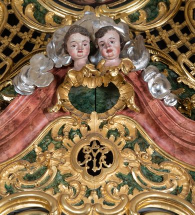 Zdjęcie nr 31: Ołtarz przyścienny, architektoniczny z mensą w formie sarkofagu o wklęsło-wypukłych bokach. W mensie kamienny portatyl. Retabulum jednoosiowe, jednokondygnacyjne ze zwieńczeniem, ustawione na wysokim zdwojonym cokole, zryzalitowanym bo bokach. Nastawa ujęta parą narożnych pilastrów kompozytowych oraz parą kolumn znacznie wysuniętych przed lico ołtarza. Kolumny o kanelowanych trzonach i kompozytowych głowicach podtrzymują faliste belkowanie. Zwieńczenie ujęte po bokach motywami „S” kształtnymi o wolutowo zwiniętych końcach, z których dolne mocno wysunięte do przodu, spoczywają na belkowaniu. Zwieńczenie zamknięte dwoma stykającymi się wolutami. Po bokach retabulum ażurowe uszaki formowane z grzebieni rocaille'owych i motywów „C” kształtnych z rzeźbioną, uskrzydloną główką anielską. 
Pole środkowe w kształcie prostokątnej wnęki z zamknięciem kształtowanym z motywów „C”. We wnęce płaskorzeźba z przedstawieniem Najświętszej Marii Panny Niepokalanie Poczętej ujęta podwójną profilowaną ramą. U dołu, po bokach wnęki dwie konsole z ustawionymi pełnoplastycznymi figurami św. Elżbiety po prawej oraz św. Anny po lewej stronie. Święta Elżbieta trzyma kartę z napisem: „IOANNES / EST / NOMEN / EIUS / Ann(…)”, a święta Anna otwartą księgę zapisaną słowami: „Merito igitur / germen eadem / Anaa divino germo reult / Spiritus pierna liberi libent / Labori qve durionustructa / Vertat am sancti ludaribusmais / Clamorite me cum opta / veram”. Ponad kolumnami, po bokach zwieńczenia dwie figury aniołów, powyżej para uskrzydlonych puttów. W zwieńczeniu owalna wnęka z obrazem przedstawiającym św. Jana Chrzciciela, ujętym podwójną ramą. 
Ołtarz bogato dekorowany. Mensa zdobiona ornamentem rocaille'owym. Pola cokołów zdobione płycinami kształtowanymi z grzebieni rocaille'owych dekorujących też fryz. Trzony kolumn i pilastrów zdobią podwieszane motywy rocaille'owe przeplatane z gałązkami róż, tworzącymi również rozległy, ażurowy kartusz nad polem środkowym. Boki zwieńczenia ujęte ażurowymi liśćmi akantu. Poniżej wnęki ażurowa, ukośna kratka regencyjna. Boki wnęki i szczyt zwieńczenia dekorowane pełnoplastycznymi rocaille'ami. 
Całość struktury ołtarza pokryta malowaną marmoryzacją w odcieniach zieleni i brązu. Detal architektoniczny złocony, pilastry srebrzone.