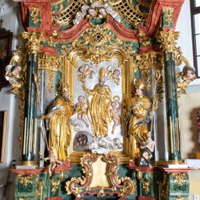 Zdjęcie nr 1: Ołtarz przyścienny, architektoniczny z mensą w formie sarkofagu o wklęsło-wypukłych bokach. W mensie kamienny portatyl. Retabulum jednoosiowe, jednokondygnacyjne ze zwieńczeniem, ustawione na wysokim zdwojonym cokole, zryzalitowanym bo bokach. Nastawa ujęta parą narożnych pilastrów kompozytowych oraz parą kolumn znacznie wysuniętych przed lico ołtarza. Kolumny o kanelowanych trzonach i kompozytowych głowicach podtrzymują faliste belkowanie. Zwieńczenie ujęte po bokach motywami „S” kształtnymi o wolutowo zwiniętych końcach, z których dolne mocno wysunięte do przodu, spoczywają na belkowaniu. Zwieńczenie zamknięte dwoma stykającymi się wolutami. Po bokach retabulum ażurowe uszaki formowane z grzebieni rocaille&#039;owych i motywów „C” kształtnych z rzeźbioną, uskrzydloną główką anielską. 
Pole środkowe w kształcie prostokątnej wnęki z zamknięciem kształtowanym z motywów „C”. We wnęce płaskorzeźba z przedstwieniem św. Mikołaja ujęta podwójną profilowaną ramą. U dołu, po bokach wnęki dwie konsole z ustawionymi pełnoplastycznymi figurami św. Augustyna po lewej oraz św. Marcina (?) po prawej stronie. Ponad kolumnami, po bokach zwieńczenia dwie figury aniołów, powyżej para uskrzydlonych puttów. W zwieńczeniu owalna wnęka z obrazem przedstawiającym św. Sebastiana, ujętym podwójną ramą. 
Ołtarz bogato dekorowany. Mensa zdobiona ornamentem rocaille&#039;owym. Pola cokołów zdobione płycinami kształtowanymi z grzebieni rocaille&#039;owych dekorujących też fryz. Trzony kolumn i pilastrów zdobią podwieszane motywy rocaille&#039;owe przeplatane z gałązkami róż, tworzącymi również rozległy, ażurowy kartusz nad polem środkowym. Boki zwieńczenia ujęte ażurowymi liśćmi akantu. Poniżej wnęki ażurowa, ukośna kratka regencyjna. Boki wnęki i szczyt zwieńczenia dekorowane pełnoplastycznymi rocaille&#039;ami. 
Całość struktury ołtarza pokryta malowaną marmoryzacją w odcieniach zieleni i brązu. Detal architektoniczny złocony, pilastry srebrzone.