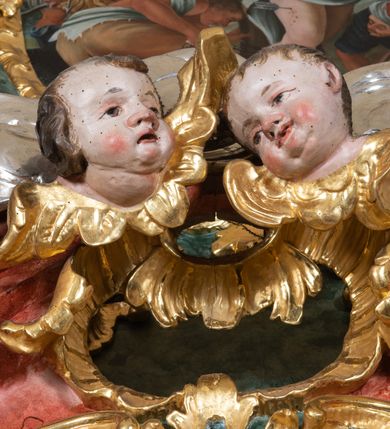 Zdjęcie nr 5: Ołtarz przyścienny, architektoniczny z mensą w formie sarkofagu o wklęsło-wypukłych bokach. W mensie kamienny portatyl. Retabulum jednoosiowe, jednokondygnacyjne ze zwieńczeniem, ustawione na wysokim zdwojonym cokole, zryzalitowanym bo bokach. Nastawa ujęta parą narożnych pilastrów kompozytowych oraz parą kolumn znacznie wysuniętych przed lico ołtarza. Kolumny o kanelowanych trzonach i kompozytowych głowicach podtrzymują faliste belkowanie. Zwieńczenie ujęte po bokach motywami „S” kształtnymi o wolutowo zwiniętych końcach, z których dolne mocno wysunięte do przodu, spoczywają na belkowaniu. Zwieńczenie zamknięte dwoma stykającymi się wolutami. Po bokach retabulum ażurowe uszaki formowane z grzebieni rocaille&#039;owych i motywów „C” kształtnych z rzeźbioną, uskrzydloną główką anielską. 
Pole środkowe w kształcie prostokątnej wnęki z zamknięciem kształtowanym z motywów „C”. We wnęce płaskorzeźba z przedstwieniem św. Mikołaja ujęta podwójną profilowaną ramą. U dołu, po bokach wnęki dwie konsole z ustawionymi pełnoplastycznymi figurami św. Augustyna po lewej oraz św. Marcina (?) po prawej stronie. Ponad kolumnami, po bokach zwieńczenia dwie figury aniołów, powyżej para uskrzydlonych puttów. W zwieńczeniu owalna wnęka z obrazem przedstawiającym św. Sebastiana, ujętym podwójną ramą. 
Ołtarz bogato dekorowany. Mensa zdobiona ornamentem rocaille&#039;owym. Pola cokołów zdobione płycinami kształtowanymi z grzebieni rocaille&#039;owych dekorujących też fryz. Trzony kolumn i pilastrów zdobią podwieszane motywy rocaille&#039;owe przeplatane z gałązkami róż, tworzącymi również rozległy, ażurowy kartusz nad polem środkowym. Boki zwieńczenia ujęte ażurowymi liśćmi akantu. Poniżej wnęki ażurowa, ukośna kratka regencyjna. Boki wnęki i szczyt zwieńczenia dekorowane pełnoplastycznymi rocaille&#039;ami. 
Całość struktury ołtarza pokryta malowaną marmoryzacją w odcieniach zieleni i brązu. Detal architektoniczny złocony, pilastry srebrzone.