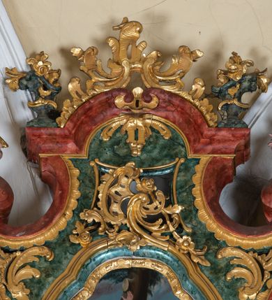 Zdjęcie nr 33: Ołtarz przyścienny, architektoniczny z mensą w formie sarkofagu o wklęsło-wypukłych bokach. W mensie kamienny portatyl. Retabulum jednoosiowe, jednokondygnacyjne ze zwieńczeniem, ustawione na wysokim zdwojonym cokole, zryzalitowanym bo bokach. Nastawa ujęta parą narożnych pilastrów kompozytowych oraz parą kolumn znacznie wysuniętych przed lico ołtarza. Kolumny o kanelowanych trzonach i kompozytowych głowicach podtrzymują faliste belkowanie. Zwieńczenie ujęte po bokach motywami „S” kształtnymi o wolutowo zwiniętych końcach, z których dolne mocno wysunięte do przodu, spoczywają na belkowaniu. Zwieńczenie zamknięte dwoma stykającymi się wolutami. Po bokach retabulum ażurowe uszaki formowane z grzebieni rocaille'owych i motywów „C” kształtnych z rzeźbioną, uskrzydloną główką anielską. 
Pole środkowe w kształcie prostokątnej wnęki z zamknięciem kształtowanym z motywów „C”. We wnęce płaskorzeźba z przedstwieniem św. Mikołaja ujęta podwójną profilowaną ramą. U dołu, po bokach wnęki dwie konsole z ustawionymi pełnoplastycznymi figurami św. Augustyna po lewej oraz św. Marcina (?) po prawej stronie. Ponad kolumnami, po bokach zwieńczenia dwie figury aniołów, powyżej para uskrzydlonych puttów. W zwieńczeniu owalna wnęka z obrazem przedstawiającym św. Sebastiana, ujętym podwójną ramą. 
Ołtarz bogato dekorowany. Mensa zdobiona ornamentem rocaille'owym. Pola cokołów zdobione płycinami kształtowanymi z grzebieni rocaille'owych dekorujących też fryz. Trzony kolumn i pilastrów zdobią podwieszane motywy rocaille'owe przeplatane z gałązkami róż, tworzącymi również rozległy, ażurowy kartusz nad polem środkowym. Boki zwieńczenia ujęte ażurowymi liśćmi akantu. Poniżej wnęki ażurowa, ukośna kratka regencyjna. Boki wnęki i szczyt zwieńczenia dekorowane pełnoplastycznymi rocaille'ami. 
Całość struktury ołtarza pokryta malowaną marmoryzacją w odcieniach zieleni i brązu. Detal architektoniczny złocony, pilastry srebrzone.