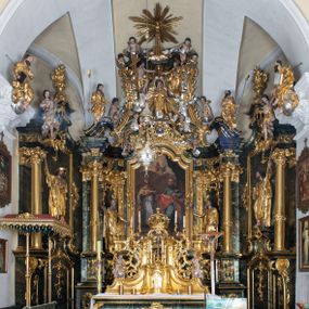 Zdjęcie nr 1: Nastawa ołtarzowa architektoniczna, trójosiowa z bramkami, jednokondygnacyjna ze zwieńczeniem. Ołtarz wysunięty do przodu, drewniany, sarkofagowy, wklęsło-wypukły, zwężający się ku dołowi, na profilowanym cokole, ujęty spływami wolutowymi; dekorowany w narożach palmetami, na froncie rocaille'owy kartusz z malowanymi skrzyżowanymi kluczami w polu. Mensa drewniana z silnie wysuniętą, profilowaną krawędzią, z portatylem z piaskowca. 

Tabernakulum w formie prostopadłościennej skrzynki o wypukłej ściance frontowej, ujęte z przodu ukośnie dostawionymi pilastrami na cokołach z trzonami w formie wolut, dźwigającymi niepełne belkowanie, opasujące je z trzech stron, nad ścianką frontową przyjmujące falistą formę zwieńczoną rocaille'm. Drzwiczki przyjmują kształt stojącego prostokąta zamkniętego łukiem półkolistym nadwieszonym, ujęte profilowaną ramą; w polu płaskorzeźbione przedstawienie kielicha z hostią w glorii na fakturowanym tle. Na belkowaniu, na osi podpór ustawiona jest para rocaille'owych lichtarzy. Tron wystawienia architektoniczny, trójosiowy; oś środkowa ponad tabernakulum w postaci ażurowej niszy z cokołem na pasyjkę, tylna ścianka utworzona z rocaille'u z kłosami zbóż; flankowana pilastrami zwieńczonymi falistym gzymsem, dźwigającymi ażurową, zamkniętą koronę. Podpory przechodzą w spływy wolutowe, ujmujące tabernakulum, na których końcach siedzi para adorujących puttów. Osie boczne są ujęte po bokach pilastrami dźwigającymi imposty podtrzymywane przez rocaille w partii trzonów oraz płonące wazony; pola wypełnione ażurowym rocaille'm i palmetami przechodzącymi w podwójne lichtarze.

Retabulum na planie półowalu, osie boczne ustawione prostopadle do środkowej. Oś środkowa posadowiona na wysokim, dwustrefowym cokole. W pierwszej strefie cokołu prostokątna płycina z napisem: „Z INICJATYWY / KS. PROBOSZCZA ROMANA GORCZYŃSKIEGO / W LATACH 2001 - 2006 / WYKONANO REMONT KOŚCIOŁA I KONSERWACJĘ / WYPOSAŻENIA”. W drugiej strefie cokołu, pośrodku płycina w formie leżącego prostokąta o fantazyjnie wyciętych bokach z malowanym kartuszem herbowym, dzielonym na cztery pola. W lewym górnym polu kartusza umieszczony jest orzeł, poniżej dwójka dzieci w łódce, a po prawej stronie tarczy, w prawym górnym polu dwójka dzieci w łódce, poniżej orzeł. U spodu napis z chronostychem: „EREXIT, AC EXORNAVIT HONORIBVS SANCTI PETRI, / AC PAVLI APOSTOLI ILLVSTRISSIMVS LIBER BAR I WNBS(?) IOANELLY / A TOLVANA PROPPII X I”. Klejnotem jest hełm z pióropuszem zakończony półpostacią rycerza w zbroi, zaś labry mają formę bujnej wici akantowej.  Ryzality cokołów ozdobione są z trzech stron rocaille'owymi płycinami; skrajne konsole rocaille'm i różanymi gałązkami. Oś główna flankowana parą kolumn ustawioną na tle zwielokrotnionych pilastrów. Podpory dźwigają pełne belkowanie, przerwane nad polem środkowym, wyłamane na ich osi oraz przerwany wolutowy przyczółek. W polu środkowym podwójna, profilowana rama w formie stojącego prostokąta zamkniętego łukiem nadwieszonym z uskokami z obrazem św. Piotra i św. Pawła; flankowana przez figury św. Szymona po lewej stronie i św. Judy Tadeusza po prawej, ustawionymi na rocaille'owych wspornikach. Ramy obrazu, trzony wewnętrznych pilastrów i pola za środkową parą figur dekorowane rocaille'm. 

Zwieńczenie w formie zbliżonej do stojącego prostokąta, ujęte spływami wolutowymi, zamknięte falistym gzymsem przechodzącym w antytetycznie zwrócone woluty. Całość zwieńczona gołębicą Ducha Świętego w glorii promienistej. W polu rzeźbiarska grupa Koronacji Marii w glorii promienistej, pośród obłoków i uskrzydlonych główek anielskich. Dwa flankujące grupę putta  na obłokach trzymają banderole z napisem: „FILIA DEI PATRIS” i „MATER DEI FILII”, a kolejne dwa usadzone na szczycie: „VENI CORONABERIS” oraz „VENI SPONSA MEA”. Poniżej zwieńczenia w ażurowym kartuszu znajduje się napis: „QVA E/ST ISTA / QVAE PROGREDI/TUR QVASI AURORA / CONSURGENS / Cant 6.”. Na przyczółku siedzące figury św. Joachima po lewej stronie i św. Józefa po prawej, na gzymsie flankującym pole środkowe dwa putta trzymające słońce i księżyc, na zewnętrznych osiach dwa adorujące anioły. Spływy zwieńczenia dekorowane strzępiastymi liśćmi palmowymi, muszlą i rocaille’m. 

Osie boczne ustawione są na wysokim cokole, od zewnątrz ujęte pilastrami przechodzącymi w woluty, od wewnątrz sąsiadują z osią środkową. Pośrodku bramki z drzwiczkami zakończonymi gzymsem przyjmującym formę cokołu dla figur. Drzwiczki w formie stojącego prostokątna zamkniętego łukiem segmentowym nadwieszonym; osie na skraju ujęte konsolami stanowiącymi cokoły dla podpór. Ryzalit bramek zdobiony płyciną ze strzępiastym grzebieniem; drzwiczki z płyciną z rocaille'm i kwiatowym zwisem na wstążce; powyższy cokół ujęty liśćmi palmowymi i rocaille'm. Kondygnacja flankowana na skraju kolumną ustawioną na tle pilastru, które podtrzymują wyłamany gzyms zakończony wolutami ujmującymi szczyt o falistym przebiegu, na którym ustawiony jest duży płomienisty wazon. W polach ustawione są figury: po lewej się Jakuba Starszego, a po prawej św. Filipa. Na zwieńczeniach usadzone dwie figury aniołów. 

Struktura w całości marmoryzowana w kolorze zielono-brązowym; ornamentyka, kolumny złocone, detale srebrzone. Wszystkie kolumny w jednej trzeciej wysokości przedzielone rocaille’m, a fryz z elementami dekoracji rokokowej. Tabernakulum i tron wystawienia w całości złocone.

