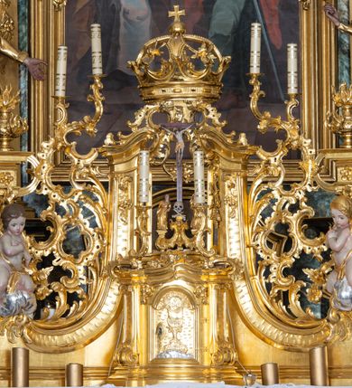 Zdjęcie nr 39: Nastawa ołtarzowa architektoniczna, trójosiowa z bramkami, jednokondygnacyjna ze zwieńczeniem. Ołtarz wysunięty do przodu, drewniany, sarkofagowy, wklęsło-wypukły, zwężający się ku dołowi, na profilowanym cokole, ujęty spływami wolutowymi; dekorowany w narożach palmetami, na froncie rocaille'owy kartusz z malowanymi skrzyżowanymi kluczami w polu. Mensa drewniana z silnie wysuniętą, profilowaną krawędzią, z portatylem z piaskowca. 

Tabernakulum w formie prostopadłościennej skrzynki o wypukłej ściance frontowej, ujęte z przodu ukośnie dostawionymi pilastrami na cokołach z trzonami w formie wolut, dźwigającymi niepełne belkowanie, opasujące je z trzech stron, nad ścianką frontową przyjmujące falistą formę zwieńczoną rocaille'm. Drzwiczki przyjmują kształt stojącego prostokąta zamkniętego łukiem półkolistym nadwieszonym, ujęte profilowaną ramą; w polu płaskorzeźbione przedstawienie kielicha z hostią w glorii na fakturowanym tle. Na belkowaniu, na osi podpór ustawiona jest para rocaille'owych lichtarzy. Tron wystawienia architektoniczny, trójosiowy; oś środkowa ponad tabernakulum w postaci ażurowej niszy z cokołem na pasyjkę, tylna ścianka utworzona z rocaille'u z kłosami zbóż; flankowana pilastrami zwieńczonymi falistym gzymsem, dźwigającymi ażurową, zamkniętą koronę. Podpory przechodzą w spływy wolutowe, ujmujące tabernakulum, na których końcach siedzi para adorujących puttów. Osie boczne są ujęte po bokach pilastrami dźwigającymi imposty podtrzymywane przez rocaille w partii trzonów oraz płonące wazony; pola wypełnione ażurowym rocaille'm i palmetami przechodzącymi w podwójne lichtarze.

Retabulum na planie półowalu, osie boczne ustawione prostopadle do środkowej. Oś środkowa posadowiona na wysokim, dwustrefowym cokole. W pierwszej strefie cokołu prostokątna płycina z napisem: „Z INICJATYWY / KS. PROBOSZCZA ROMANA GORCZYŃSKIEGO / W LATACH 2001 - 2006 / WYKONANO REMONT KOŚCIOŁA I KONSERWACJĘ / WYPOSAŻENIA”. W drugiej strefie cokołu, pośrodku płycina w formie leżącego prostokąta o fantazyjnie wyciętych bokach z malowanym kartuszem herbowym, dzielonym na cztery pola. W lewym górnym polu kartusza umieszczony jest orzeł, poniżej dwójka dzieci w łódce, a po prawej stronie tarczy, w prawym górnym polu dwójka dzieci w łódce, poniżej orzeł. U spodu napis z chronostychem: „EREXIT, AC EXORNAVIT HONORIBVS SANCTI PETRI, / AC PAVLI APOSTOLI ILLVSTRISSIMVS LIBER BAR I WNBS(?) IOANELLY / A TOLVANA PROPPII X I”. Klejnotem jest hełm z pióropuszem zakończony półpostacią rycerza w zbroi, zaś labry mają formę bujnej wici akantowej.  Ryzality cokołów ozdobione są z trzech stron rocaille'owymi płycinami; skrajne konsole rocaille'm i różanymi gałązkami. Oś główna flankowana parą kolumn ustawioną na tle zwielokrotnionych pilastrów. Podpory dźwigają pełne belkowanie, przerwane nad polem środkowym, wyłamane na ich osi oraz przerwany wolutowy przyczółek. W polu środkowym podwójna, profilowana rama w formie stojącego prostokąta zamkniętego łukiem nadwieszonym z uskokami z obrazem św. Piotra i św. Pawła; flankowana przez figury św. Szymona po lewej stronie i św. Judy Tadeusza po prawej, ustawionymi na rocaille'owych wspornikach. Ramy obrazu, trzony wewnętrznych pilastrów i pola za środkową parą figur dekorowane rocaille'm. 

Zwieńczenie w formie zbliżonej do stojącego prostokąta, ujęte spływami wolutowymi, zamknięte falistym gzymsem przechodzącym w antytetycznie zwrócone woluty. Całość zwieńczona gołębicą Ducha Świętego w glorii promienistej. W polu rzeźbiarska grupa Koronacji Marii w glorii promienistej, pośród obłoków i uskrzydlonych główek anielskich. Dwa flankujące grupę putta  na obłokach trzymają banderole z napisem: „FILIA DEI PATRIS” i „MATER DEI FILII”, a kolejne dwa usadzone na szczycie: „VENI CORONABERIS” oraz „VENI SPONSA MEA”. Poniżej zwieńczenia w ażurowym kartuszu znajduje się napis: „QVA E/ST ISTA / QVAE PROGREDI/TUR QVASI AURORA / CONSURGENS / Cant 6.”. Na przyczółku siedzące figury św. Joachima po lewej stronie i św. Józefa po prawej, na gzymsie flankującym pole środkowe dwa putta trzymające słońce i księżyc, na zewnętrznych osiach dwa adorujące anioły. Spływy zwieńczenia dekorowane strzępiastymi liśćmi palmowymi, muszlą i rocaille’m. 

Osie boczne ustawione są na wysokim cokole, od zewnątrz ujęte pilastrami przechodzącymi w woluty, od wewnątrz sąsiadują z osią środkową. Pośrodku bramki z drzwiczkami zakończonymi gzymsem przyjmującym formę cokołu dla figur. Drzwiczki w formie stojącego prostokątna zamkniętego łukiem segmentowym nadwieszonym; osie na skraju ujęte konsolami stanowiącymi cokoły dla podpór. Ryzalit bramek zdobiony płyciną ze strzępiastym grzebieniem; drzwiczki z płyciną z rocaille'm i kwiatowym zwisem na wstążce; powyższy cokół ujęty liśćmi palmowymi i rocaille'm. Kondygnacja flankowana na skraju kolumną ustawioną na tle pilastru, które podtrzymują wyłamany gzyms zakończony wolutami ujmującymi szczyt o falistym przebiegu, na którym ustawiony jest duży płomienisty wazon. W polach ustawione są figury: po lewej się Jakuba Starszego, a po prawej św. Filipa. Na zwieńczeniach usadzone dwie figury aniołów. 

Struktura w całości marmoryzowana w kolorze zielono-brązowym; ornamentyka, kolumny złocone, detale srebrzone. Wszystkie kolumny w jednej trzeciej wysokości przedzielone rocaille’m, a fryz z elementami dekoracji rokokowej. Tabernakulum i tron wystawienia w całości złocone.

