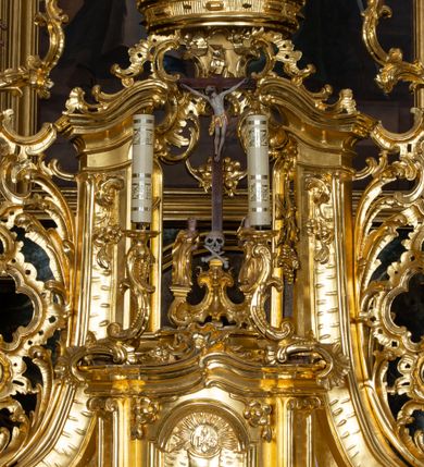 Zdjęcie nr 38: Nastawa ołtarzowa architektoniczna, trójosiowa z bramkami, jednokondygnacyjna ze zwieńczeniem. Ołtarz wysunięty do przodu, drewniany, sarkofagowy, wklęsło-wypukły, zwężający się ku dołowi, na profilowanym cokole, ujęty spływami wolutowymi; dekorowany w narożach palmetami, na froncie rocaille'owy kartusz z malowanymi skrzyżowanymi kluczami w polu. Mensa drewniana z silnie wysuniętą, profilowaną krawędzią, z portatylem z piaskowca. 

Tabernakulum w formie prostopadłościennej skrzynki o wypukłej ściance frontowej, ujęte z przodu ukośnie dostawionymi pilastrami na cokołach z trzonami w formie wolut, dźwigającymi niepełne belkowanie, opasujące je z trzech stron, nad ścianką frontową przyjmujące falistą formę zwieńczoną rocaille'm. Drzwiczki przyjmują kształt stojącego prostokąta zamkniętego łukiem półkolistym nadwieszonym, ujęte profilowaną ramą; w polu płaskorzeźbione przedstawienie kielicha z hostią w glorii na fakturowanym tle. Na belkowaniu, na osi podpór ustawiona jest para rocaille'owych lichtarzy. Tron wystawienia architektoniczny, trójosiowy; oś środkowa ponad tabernakulum w postaci ażurowej niszy z cokołem na pasyjkę, tylna ścianka utworzona z rocaille'u z kłosami zbóż; flankowana pilastrami zwieńczonymi falistym gzymsem, dźwigającymi ażurową, zamkniętą koronę. Podpory przechodzą w spływy wolutowe, ujmujące tabernakulum, na których końcach siedzi para adorujących puttów. Osie boczne są ujęte po bokach pilastrami dźwigającymi imposty podtrzymywane przez rocaille w partii trzonów oraz płonące wazony; pola wypełnione ażurowym rocaille'm i palmetami przechodzącymi w podwójne lichtarze.

Retabulum na planie półowalu, osie boczne ustawione prostopadle do środkowej. Oś środkowa posadowiona na wysokim, dwustrefowym cokole. W pierwszej strefie cokołu prostokątna płycina z napisem: „Z INICJATYWY / KS. PROBOSZCZA ROMANA GORCZYŃSKIEGO / W LATACH 2001 - 2006 / WYKONANO REMONT KOŚCIOŁA I KONSERWACJĘ / WYPOSAŻENIA”. W drugiej strefie cokołu, pośrodku płycina w formie leżącego prostokąta o fantazyjnie wyciętych bokach z malowanym kartuszem herbowym, dzielonym na cztery pola. W lewym górnym polu kartusza umieszczony jest orzeł, poniżej dwójka dzieci w łódce, a po prawej stronie tarczy, w prawym górnym polu dwójka dzieci w łódce, poniżej orzeł. U spodu napis z chronostychem: „EREXIT, AC EXORNAVIT HONORIBVS SANCTI PETRI, / AC PAVLI APOSTOLI ILLVSTRISSIMVS LIBER BAR I WNBS(?) IOANELLY / A TOLVANA PROPPII X I”. Klejnotem jest hełm z pióropuszem zakończony półpostacią rycerza w zbroi, zaś labry mają formę bujnej wici akantowej.  Ryzality cokołów ozdobione są z trzech stron rocaille'owymi płycinami; skrajne konsole rocaille'm i różanymi gałązkami. Oś główna flankowana parą kolumn ustawioną na tle zwielokrotnionych pilastrów. Podpory dźwigają pełne belkowanie, przerwane nad polem środkowym, wyłamane na ich osi oraz przerwany wolutowy przyczółek. W polu środkowym podwójna, profilowana rama w formie stojącego prostokąta zamkniętego łukiem nadwieszonym z uskokami z obrazem św. Piotra i św. Pawła; flankowana przez figury św. Szymona po lewej stronie i św. Judy Tadeusza po prawej, ustawionymi na rocaille'owych wspornikach. Ramy obrazu, trzony wewnętrznych pilastrów i pola za środkową parą figur dekorowane rocaille'm. 

Zwieńczenie w formie zbliżonej do stojącego prostokąta, ujęte spływami wolutowymi, zamknięte falistym gzymsem przechodzącym w antytetycznie zwrócone woluty. Całość zwieńczona gołębicą Ducha Świętego w glorii promienistej. W polu rzeźbiarska grupa Koronacji Marii w glorii promienistej, pośród obłoków i uskrzydlonych główek anielskich. Dwa flankujące grupę putta  na obłokach trzymają banderole z napisem: „FILIA DEI PATRIS” i „MATER DEI FILII”, a kolejne dwa usadzone na szczycie: „VENI CORONABERIS” oraz „VENI SPONSA MEA”. Poniżej zwieńczenia w ażurowym kartuszu znajduje się napis: „QVA E/ST ISTA / QVAE PROGREDI/TUR QVASI AURORA / CONSURGENS / Cant 6.”. Na przyczółku siedzące figury św. Joachima po lewej stronie i św. Józefa po prawej, na gzymsie flankującym pole środkowe dwa putta trzymające słońce i księżyc, na zewnętrznych osiach dwa adorujące anioły. Spływy zwieńczenia dekorowane strzępiastymi liśćmi palmowymi, muszlą i rocaille’m. 

Osie boczne ustawione są na wysokim cokole, od zewnątrz ujęte pilastrami przechodzącymi w woluty, od wewnątrz sąsiadują z osią środkową. Pośrodku bramki z drzwiczkami zakończonymi gzymsem przyjmującym formę cokołu dla figur. Drzwiczki w formie stojącego prostokątna zamkniętego łukiem segmentowym nadwieszonym; osie na skraju ujęte konsolami stanowiącymi cokoły dla podpór. Ryzalit bramek zdobiony płyciną ze strzępiastym grzebieniem; drzwiczki z płyciną z rocaille'm i kwiatowym zwisem na wstążce; powyższy cokół ujęty liśćmi palmowymi i rocaille'm. Kondygnacja flankowana na skraju kolumną ustawioną na tle pilastru, które podtrzymują wyłamany gzyms zakończony wolutami ujmującymi szczyt o falistym przebiegu, na którym ustawiony jest duży płomienisty wazon. W polach ustawione są figury: po lewej się Jakuba Starszego, a po prawej św. Filipa. Na zwieńczeniach usadzone dwie figury aniołów. 

Struktura w całości marmoryzowana w kolorze zielono-brązowym; ornamentyka, kolumny złocone, detale srebrzone. Wszystkie kolumny w jednej trzeciej wysokości przedzielone rocaille’m, a fryz z elementami dekoracji rokokowej. Tabernakulum i tron wystawienia w całości złocone.

