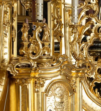 Zdjęcie nr 41: Nastawa ołtarzowa architektoniczna, trójosiowa z bramkami, jednokondygnacyjna ze zwieńczeniem. Ołtarz wysunięty do przodu, drewniany, sarkofagowy, wklęsło-wypukły, zwężający się ku dołowi, na profilowanym cokole, ujęty spływami wolutowymi; dekorowany w narożach palmetami, na froncie rocaille&#039;owy kartusz z malowanymi skrzyżowanymi kluczami w polu. Mensa drewniana z silnie wysuniętą, profilowaną krawędzią, z portatylem z piaskowca. 

Tabernakulum w formie prostopadłościennej skrzynki o wypukłej ściance frontowej, ujęte z przodu ukośnie dostawionymi pilastrami na cokołach z trzonami w formie wolut, dźwigającymi niepełne belkowanie, opasujące je z trzech stron, nad ścianką frontową przyjmujące falistą formę zwieńczoną rocaille&#039;m. Drzwiczki przyjmują kształt stojącego prostokąta zamkniętego łukiem półkolistym nadwieszonym, ujęte profilowaną ramą; w polu płaskorzeźbione przedstawienie kielicha z hostią w glorii na fakturowanym tle. Na belkowaniu, na osi podpór ustawiona jest para rocaille&#039;owych lichtarzy. Tron wystawienia architektoniczny, trójosiowy; oś środkowa ponad tabernakulum w postaci ażurowej niszy z cokołem na pasyjkę, tylna ścianka utworzona z rocaille&#039;u z kłosami zbóż; flankowana pilastrami zwieńczonymi falistym gzymsem, dźwigającymi ażurową, zamkniętą koronę. Podpory przechodzą w spływy wolutowe, ujmujące tabernakulum, na których końcach siedzi para adorujących puttów. Osie boczne są ujęte po bokach pilastrami dźwigającymi imposty podtrzymywane przez rocaille w partii trzonów oraz płonące wazony; pola wypełnione ażurowym rocaille&#039;m i palmetami przechodzącymi w podwójne lichtarze.

Retabulum na planie półowalu, osie boczne ustawione prostopadle do środkowej. Oś środkowa posadowiona na wysokim, dwustrefowym cokole. W pierwszej strefie cokołu prostokątna płycina z napisem: „Z INICJATYWY / KS. PROBOSZCZA ROMANA GORCZYŃSKIEGO / W LATACH 2001 - 2006 / WYKONANO REMONT KOŚCIOŁA I KONSERWACJĘ / WYPOSAŻENIA”. W drugiej strefie cokołu, pośrodku płycina w formie leżącego prostokąta o fantazyjnie wyciętych bokach z malowanym kartuszem herbowym, dzielonym na cztery pola. W lewym górnym polu kartusza umieszczony jest orzeł, poniżej dwójka dzieci w łódce, a po prawej stronie tarczy, w prawym górnym polu dwójka dzieci w łódce, poniżej orzeł. U spodu napis z chronostychem: „EREXIT, AC EXORNAVIT HONORIBVS SANCTI PETRI, / AC PAVLI APOSTOLI ILLVSTRISSIMVS LIBER BAR I WNBS(?) IOANELLY / A TOLVANA PROPPII X I”. Klejnotem jest hełm z pióropuszem zakończony półpostacią rycerza w zbroi, zaś labry mają formę bujnej wici akantowej.  Ryzality cokołów ozdobione są z trzech stron rocaille&#039;owymi płycinami; skrajne konsole rocaille&#039;m i różanymi gałązkami. Oś główna flankowana parą kolumn ustawioną na tle zwielokrotnionych pilastrów. Podpory dźwigają pełne belkowanie, przerwane nad polem środkowym, wyłamane na ich osi oraz przerwany wolutowy przyczółek. W polu środkowym podwójna, profilowana rama w formie stojącego prostokąta zamkniętego łukiem nadwieszonym z uskokami z obrazem św. Piotra i św. Pawła; flankowana przez figury św. Szymona po lewej stronie i św. Judy Tadeusza po prawej, ustawionymi na rocaille&#039;owych wspornikach. Ramy obrazu, trzony wewnętrznych pilastrów i pola za środkową parą figur dekorowane rocaille&#039;m. 

Zwieńczenie w formie zbliżonej do stojącego prostokąta, ujęte spływami wolutowymi, zamknięte falistym gzymsem przechodzącym w antytetycznie zwrócone woluty. Całość zwieńczona gołębicą Ducha Świętego w glorii promienistej. W polu rzeźbiarska grupa Koronacji Marii w glorii promienistej, pośród obłoków i uskrzydlonych główek anielskich. Dwa flankujące grupę putta  na obłokach trzymają banderole z napisem: „FILIA DEI PATRIS” i „MATER DEI FILII”, a kolejne dwa usadzone na szczycie: „VENI CORONABERIS” oraz „VENI SPONSA MEA”. Poniżej zwieńczenia w ażurowym kartuszu znajduje się napis: „QVA E/ST ISTA / QVAE PROGREDI/TUR QVASI AURORA / CONSURGENS / Cant 6.”. Na przyczółku siedzące figury św. Joachima po lewej stronie i św. Józefa po prawej, na gzymsie flankującym pole środkowe dwa putta trzymające słońce i księżyc, na zewnętrznych osiach dwa adorujące anioły. Spływy zwieńczenia dekorowane strzępiastymi liśćmi palmowymi, muszlą i rocaille’m. 

Osie boczne ustawione są na wysokim cokole, od zewnątrz ujęte pilastrami przechodzącymi w woluty, od wewnątrz sąsiadują z osią środkową. Pośrodku bramki z drzwiczkami zakończonymi gzymsem przyjmującym formę cokołu dla figur. Drzwiczki w formie stojącego prostokątna zamkniętego łukiem segmentowym nadwieszonym; osie na skraju ujęte konsolami stanowiącymi cokoły dla podpór. Ryzalit bramek zdobiony płyciną ze strzępiastym grzebieniem; drzwiczki z płyciną z rocaille&#039;m i kwiatowym zwisem na wstążce; powyższy cokół ujęty liśćmi palmowymi i rocaille&#039;m. Kondygnacja flankowana na skraju kolumną ustawioną na tle pilastru, które podtrzymują wyłamany gzyms zakończony wolutami ujmującymi szczyt o falistym przebiegu, na którym ustawiony jest duży płomienisty wazon. W polach ustawione są figury: po lewej się Jakuba Starszego, a po prawej św. Filipa. Na zwieńczeniach usadzone dwie figury aniołów. 

Struktura w całości marmoryzowana w kolorze zielono-brązowym; ornamentyka, kolumny złocone, detale srebrzone. Wszystkie kolumny w jednej trzeciej wysokości przedzielone rocaille’m, a fryz z elementami dekoracji rokokowej. Tabernakulum i tron wystawienia w całości złocone.

