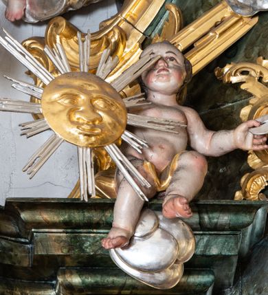 Zdjęcie nr 14: Nastawa ołtarzowa architektoniczna, trójosiowa z bramkami, jednokondygnacyjna ze zwieńczeniem. Ołtarz wysunięty do przodu, drewniany, sarkofagowy, wklęsło-wypukły, zwężający się ku dołowi, na profilowanym cokole, ujęty spływami wolutowymi; dekorowany w narożach palmetami, na froncie rocaille'owy kartusz z malowanymi skrzyżowanymi kluczami w polu. Mensa drewniana z silnie wysuniętą, profilowaną krawędzią, z portatylem z piaskowca. 

Tabernakulum w formie prostopadłościennej skrzynki o wypukłej ściance frontowej, ujęte z przodu ukośnie dostawionymi pilastrami na cokołach z trzonami w formie wolut, dźwigającymi niepełne belkowanie, opasujące je z trzech stron, nad ścianką frontową przyjmujące falistą formę zwieńczoną rocaille'm. Drzwiczki przyjmują kształt stojącego prostokąta zamkniętego łukiem półkolistym nadwieszonym, ujęte profilowaną ramą; w polu płaskorzeźbione przedstawienie kielicha z hostią w glorii na fakturowanym tle. Na belkowaniu, na osi podpór ustawiona jest para rocaille'owych lichtarzy. Tron wystawienia architektoniczny, trójosiowy; oś środkowa ponad tabernakulum w postaci ażurowej niszy z cokołem na pasyjkę, tylna ścianka utworzona z rocaille'u z kłosami zbóż; flankowana pilastrami zwieńczonymi falistym gzymsem, dźwigającymi ażurową, zamkniętą koronę. Podpory przechodzą w spływy wolutowe, ujmujące tabernakulum, na których końcach siedzi para adorujących puttów. Osie boczne są ujęte po bokach pilastrami dźwigającymi imposty podtrzymywane przez rocaille w partii trzonów oraz płonące wazony; pola wypełnione ażurowym rocaille'm i palmetami przechodzącymi w podwójne lichtarze.

Retabulum na planie półowalu, osie boczne ustawione prostopadle do środkowej. Oś środkowa posadowiona na wysokim, dwustrefowym cokole. W pierwszej strefie cokołu prostokątna płycina z napisem: „Z INICJATYWY / KS. PROBOSZCZA ROMANA GORCZYŃSKIEGO / W LATACH 2001 - 2006 / WYKONANO REMONT KOŚCIOŁA I KONSERWACJĘ / WYPOSAŻENIA”. W drugiej strefie cokołu, pośrodku płycina w formie leżącego prostokąta o fantazyjnie wyciętych bokach z malowanym kartuszem herbowym, dzielonym na cztery pola. W lewym górnym polu kartusza umieszczony jest orzeł, poniżej dwójka dzieci w łódce, a po prawej stronie tarczy, w prawym górnym polu dwójka dzieci w łódce, poniżej orzeł. U spodu napis z chronostychem: „EREXIT, AC EXORNAVIT HONORIBVS SANCTI PETRI, / AC PAVLI APOSTOLI ILLVSTRISSIMVS LIBER BAR I WNBS(?) IOANELLY / A TOLVANA PROPPII X I”. Klejnotem jest hełm z pióropuszem zakończony półpostacią rycerza w zbroi, zaś labry mają formę bujnej wici akantowej.  Ryzality cokołów ozdobione są z trzech stron rocaille'owymi płycinami; skrajne konsole rocaille'm i różanymi gałązkami. Oś główna flankowana parą kolumn ustawioną na tle zwielokrotnionych pilastrów. Podpory dźwigają pełne belkowanie, przerwane nad polem środkowym, wyłamane na ich osi oraz przerwany wolutowy przyczółek. W polu środkowym podwójna, profilowana rama w formie stojącego prostokąta zamkniętego łukiem nadwieszonym z uskokami z obrazem św. Piotra i św. Pawła; flankowana przez figury św. Szymona po lewej stronie i św. Judy Tadeusza po prawej, ustawionymi na rocaille'owych wspornikach. Ramy obrazu, trzony wewnętrznych pilastrów i pola za środkową parą figur dekorowane rocaille'm. 

Zwieńczenie w formie zbliżonej do stojącego prostokąta, ujęte spływami wolutowymi, zamknięte falistym gzymsem przechodzącym w antytetycznie zwrócone woluty. Całość zwieńczona gołębicą Ducha Świętego w glorii promienistej. W polu rzeźbiarska grupa Koronacji Marii w glorii promienistej, pośród obłoków i uskrzydlonych główek anielskich. Dwa flankujące grupę putta  na obłokach trzymają banderole z napisem: „FILIA DEI PATRIS” i „MATER DEI FILII”, a kolejne dwa usadzone na szczycie: „VENI CORONABERIS” oraz „VENI SPONSA MEA”. Poniżej zwieńczenia w ażurowym kartuszu znajduje się napis: „QVA E/ST ISTA / QVAE PROGREDI/TUR QVASI AURORA / CONSURGENS / Cant 6.”. Na przyczółku siedzące figury św. Joachima po lewej stronie i św. Józefa po prawej, na gzymsie flankującym pole środkowe dwa putta trzymające słońce i księżyc, na zewnętrznych osiach dwa adorujące anioły. Spływy zwieńczenia dekorowane strzępiastymi liśćmi palmowymi, muszlą i rocaille’m. 

Osie boczne ustawione są na wysokim cokole, od zewnątrz ujęte pilastrami przechodzącymi w woluty, od wewnątrz sąsiadują z osią środkową. Pośrodku bramki z drzwiczkami zakończonymi gzymsem przyjmującym formę cokołu dla figur. Drzwiczki w formie stojącego prostokątna zamkniętego łukiem segmentowym nadwieszonym; osie na skraju ujęte konsolami stanowiącymi cokoły dla podpór. Ryzalit bramek zdobiony płyciną ze strzępiastym grzebieniem; drzwiczki z płyciną z rocaille'm i kwiatowym zwisem na wstążce; powyższy cokół ujęty liśćmi palmowymi i rocaille'm. Kondygnacja flankowana na skraju kolumną ustawioną na tle pilastru, które podtrzymują wyłamany gzyms zakończony wolutami ujmującymi szczyt o falistym przebiegu, na którym ustawiony jest duży płomienisty wazon. W polach ustawione są figury: po lewej się Jakuba Starszego, a po prawej św. Filipa. Na zwieńczeniach usadzone dwie figury aniołów. 

Struktura w całości marmoryzowana w kolorze zielono-brązowym; ornamentyka, kolumny złocone, detale srebrzone. Wszystkie kolumny w jednej trzeciej wysokości przedzielone rocaille’m, a fryz z elementami dekoracji rokokowej. Tabernakulum i tron wystawienia w całości złocone.

