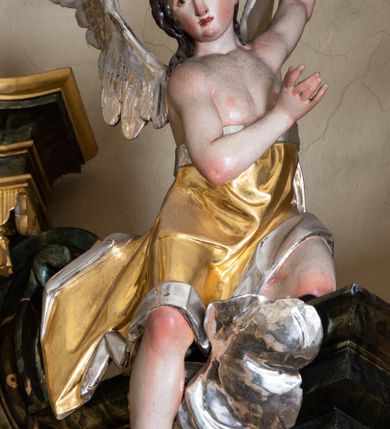 Zdjęcie nr 16: Nastawa ołtarzowa architektoniczna, trójosiowa z bramkami, jednokondygnacyjna ze zwieńczeniem. Ołtarz wysunięty do przodu, drewniany, sarkofagowy, wklęsło-wypukły, zwężający się ku dołowi, na profilowanym cokole, ujęty spływami wolutowymi; dekorowany w narożach palmetami, na froncie rocaille&#039;owy kartusz z malowanymi skrzyżowanymi kluczami w polu. Mensa drewniana z silnie wysuniętą, profilowaną krawędzią, z portatylem z piaskowca. 

Tabernakulum w formie prostopadłościennej skrzynki o wypukłej ściance frontowej, ujęte z przodu ukośnie dostawionymi pilastrami na cokołach z trzonami w formie wolut, dźwigającymi niepełne belkowanie, opasujące je z trzech stron, nad ścianką frontową przyjmujące falistą formę zwieńczoną rocaille&#039;m. Drzwiczki przyjmują kształt stojącego prostokąta zamkniętego łukiem półkolistym nadwieszonym, ujęte profilowaną ramą; w polu płaskorzeźbione przedstawienie kielicha z hostią w glorii na fakturowanym tle. Na belkowaniu, na osi podpór ustawiona jest para rocaille&#039;owych lichtarzy. Tron wystawienia architektoniczny, trójosiowy; oś środkowa ponad tabernakulum w postaci ażurowej niszy z cokołem na pasyjkę, tylna ścianka utworzona z rocaille&#039;u z kłosami zbóż; flankowana pilastrami zwieńczonymi falistym gzymsem, dźwigającymi ażurową, zamkniętą koronę. Podpory przechodzą w spływy wolutowe, ujmujące tabernakulum, na których końcach siedzi para adorujących puttów. Osie boczne są ujęte po bokach pilastrami dźwigającymi imposty podtrzymywane przez rocaille w partii trzonów oraz płonące wazony; pola wypełnione ażurowym rocaille&#039;m i palmetami przechodzącymi w podwójne lichtarze.

Retabulum na planie półowalu, osie boczne ustawione prostopadle do środkowej. Oś środkowa posadowiona na wysokim, dwustrefowym cokole. W pierwszej strefie cokołu prostokątna płycina z napisem: „Z INICJATYWY / KS. PROBOSZCZA ROMANA GORCZYŃSKIEGO / W LATACH 2001 - 2006 / WYKONANO REMONT KOŚCIOŁA I KONSERWACJĘ / WYPOSAŻENIA”. W drugiej strefie cokołu, pośrodku płycina w formie leżącego prostokąta o fantazyjnie wyciętych bokach z malowanym kartuszem herbowym, dzielonym na cztery pola. W lewym górnym polu kartusza umieszczony jest orzeł, poniżej dwójka dzieci w łódce, a po prawej stronie tarczy, w prawym górnym polu dwójka dzieci w łódce, poniżej orzeł. U spodu napis z chronostychem: „EREXIT, AC EXORNAVIT HONORIBVS SANCTI PETRI, / AC PAVLI APOSTOLI ILLVSTRISSIMVS LIBER BAR I WNBS(?) IOANELLY / A TOLVANA PROPPII X I”. Klejnotem jest hełm z pióropuszem zakończony półpostacią rycerza w zbroi, zaś labry mają formę bujnej wici akantowej.  Ryzality cokołów ozdobione są z trzech stron rocaille&#039;owymi płycinami; skrajne konsole rocaille&#039;m i różanymi gałązkami. Oś główna flankowana parą kolumn ustawioną na tle zwielokrotnionych pilastrów. Podpory dźwigają pełne belkowanie, przerwane nad polem środkowym, wyłamane na ich osi oraz przerwany wolutowy przyczółek. W polu środkowym podwójna, profilowana rama w formie stojącego prostokąta zamkniętego łukiem nadwieszonym z uskokami z obrazem św. Piotra i św. Pawła; flankowana przez figury św. Szymona po lewej stronie i św. Judy Tadeusza po prawej, ustawionymi na rocaille&#039;owych wspornikach. Ramy obrazu, trzony wewnętrznych pilastrów i pola za środkową parą figur dekorowane rocaille&#039;m. 

Zwieńczenie w formie zbliżonej do stojącego prostokąta, ujęte spływami wolutowymi, zamknięte falistym gzymsem przechodzącym w antytetycznie zwrócone woluty. Całość zwieńczona gołębicą Ducha Świętego w glorii promienistej. W polu rzeźbiarska grupa Koronacji Marii w glorii promienistej, pośród obłoków i uskrzydlonych główek anielskich. Dwa flankujące grupę putta  na obłokach trzymają banderole z napisem: „FILIA DEI PATRIS” i „MATER DEI FILII”, a kolejne dwa usadzone na szczycie: „VENI CORONABERIS” oraz „VENI SPONSA MEA”. Poniżej zwieńczenia w ażurowym kartuszu znajduje się napis: „QVA E/ST ISTA / QVAE PROGREDI/TUR QVASI AURORA / CONSURGENS / Cant 6.”. Na przyczółku siedzące figury św. Joachima po lewej stronie i św. Józefa po prawej, na gzymsie flankującym pole środkowe dwa putta trzymające słońce i księżyc, na zewnętrznych osiach dwa adorujące anioły. Spływy zwieńczenia dekorowane strzępiastymi liśćmi palmowymi, muszlą i rocaille’m. 

Osie boczne ustawione są na wysokim cokole, od zewnątrz ujęte pilastrami przechodzącymi w woluty, od wewnątrz sąsiadują z osią środkową. Pośrodku bramki z drzwiczkami zakończonymi gzymsem przyjmującym formę cokołu dla figur. Drzwiczki w formie stojącego prostokątna zamkniętego łukiem segmentowym nadwieszonym; osie na skraju ujęte konsolami stanowiącymi cokoły dla podpór. Ryzalit bramek zdobiony płyciną ze strzępiastym grzebieniem; drzwiczki z płyciną z rocaille&#039;m i kwiatowym zwisem na wstążce; powyższy cokół ujęty liśćmi palmowymi i rocaille&#039;m. Kondygnacja flankowana na skraju kolumną ustawioną na tle pilastru, które podtrzymują wyłamany gzyms zakończony wolutami ujmującymi szczyt o falistym przebiegu, na którym ustawiony jest duży płomienisty wazon. W polach ustawione są figury: po lewej się Jakuba Starszego, a po prawej św. Filipa. Na zwieńczeniach usadzone dwie figury aniołów. 

Struktura w całości marmoryzowana w kolorze zielono-brązowym; ornamentyka, kolumny złocone, detale srebrzone. Wszystkie kolumny w jednej trzeciej wysokości przedzielone rocaille’m, a fryz z elementami dekoracji rokokowej. Tabernakulum i tron wystawienia w całości złocone.

