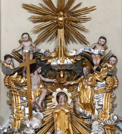 Zdjęcie nr 9: Nastawa ołtarzowa architektoniczna, trójosiowa z bramkami, jednokondygnacyjna ze zwieńczeniem. Ołtarz wysunięty do przodu, drewniany, sarkofagowy, wklęsło-wypukły, zwężający się ku dołowi, na profilowanym cokole, ujęty spływami wolutowymi; dekorowany w narożach palmetami, na froncie rocaille'owy kartusz z malowanymi skrzyżowanymi kluczami w polu. Mensa drewniana z silnie wysuniętą, profilowaną krawędzią, z portatylem z piaskowca. 

Tabernakulum w formie prostopadłościennej skrzynki o wypukłej ściance frontowej, ujęte z przodu ukośnie dostawionymi pilastrami na cokołach z trzonami w formie wolut, dźwigającymi niepełne belkowanie, opasujące je z trzech stron, nad ścianką frontową przyjmujące falistą formę zwieńczoną rocaille'm. Drzwiczki przyjmują kształt stojącego prostokąta zamkniętego łukiem półkolistym nadwieszonym, ujęte profilowaną ramą; w polu płaskorzeźbione przedstawienie kielicha z hostią w glorii na fakturowanym tle. Na belkowaniu, na osi podpór ustawiona jest para rocaille'owych lichtarzy. Tron wystawienia architektoniczny, trójosiowy; oś środkowa ponad tabernakulum w postaci ażurowej niszy z cokołem na pasyjkę, tylna ścianka utworzona z rocaille'u z kłosami zbóż; flankowana pilastrami zwieńczonymi falistym gzymsem, dźwigającymi ażurową, zamkniętą koronę. Podpory przechodzą w spływy wolutowe, ujmujące tabernakulum, na których końcach siedzi para adorujących puttów. Osie boczne są ujęte po bokach pilastrami dźwigającymi imposty podtrzymywane przez rocaille w partii trzonów oraz płonące wazony; pola wypełnione ażurowym rocaille'm i palmetami przechodzącymi w podwójne lichtarze.

Retabulum na planie półowalu, osie boczne ustawione prostopadle do środkowej. Oś środkowa posadowiona na wysokim, dwustrefowym cokole. W pierwszej strefie cokołu prostokątna płycina z napisem: „Z INICJATYWY / KS. PROBOSZCZA ROMANA GORCZYŃSKIEGO / W LATACH 2001 - 2006 / WYKONANO REMONT KOŚCIOŁA I KONSERWACJĘ / WYPOSAŻENIA”. W drugiej strefie cokołu, pośrodku płycina w formie leżącego prostokąta o fantazyjnie wyciętych bokach z malowanym kartuszem herbowym, dzielonym na cztery pola. W lewym górnym polu kartusza umieszczony jest orzeł, poniżej dwójka dzieci w łódce, a po prawej stronie tarczy, w prawym górnym polu dwójka dzieci w łódce, poniżej orzeł. U spodu napis z chronostychem: „EREXIT, AC EXORNAVIT HONORIBVS SANCTI PETRI, / AC PAVLI APOSTOLI ILLVSTRISSIMVS LIBER BAR I WNBS(?) IOANELLY / A TOLVANA PROPPII X I”. Klejnotem jest hełm z pióropuszem zakończony półpostacią rycerza w zbroi, zaś labry mają formę bujnej wici akantowej.  Ryzality cokołów ozdobione są z trzech stron rocaille'owymi płycinami; skrajne konsole rocaille'm i różanymi gałązkami. Oś główna flankowana parą kolumn ustawioną na tle zwielokrotnionych pilastrów. Podpory dźwigają pełne belkowanie, przerwane nad polem środkowym, wyłamane na ich osi oraz przerwany wolutowy przyczółek. W polu środkowym podwójna, profilowana rama w formie stojącego prostokąta zamkniętego łukiem nadwieszonym z uskokami z obrazem św. Piotra i św. Pawła; flankowana przez figury św. Szymona po lewej stronie i św. Judy Tadeusza po prawej, ustawionymi na rocaille'owych wspornikach. Ramy obrazu, trzony wewnętrznych pilastrów i pola za środkową parą figur dekorowane rocaille'm. 

Zwieńczenie w formie zbliżonej do stojącego prostokąta, ujęte spływami wolutowymi, zamknięte falistym gzymsem przechodzącym w antytetycznie zwrócone woluty. Całość zwieńczona gołębicą Ducha Świętego w glorii promienistej. W polu rzeźbiarska grupa Koronacji Marii w glorii promienistej, pośród obłoków i uskrzydlonych główek anielskich. Dwa flankujące grupę putta  na obłokach trzymają banderole z napisem: „FILIA DEI PATRIS” i „MATER DEI FILII”, a kolejne dwa usadzone na szczycie: „VENI CORONABERIS” oraz „VENI SPONSA MEA”. Poniżej zwieńczenia w ażurowym kartuszu znajduje się napis: „QVA E/ST ISTA / QVAE PROGREDI/TUR QVASI AURORA / CONSURGENS / Cant 6.”. Na przyczółku siedzące figury św. Joachima po lewej stronie i św. Józefa po prawej, na gzymsie flankującym pole środkowe dwa putta trzymające słońce i księżyc, na zewnętrznych osiach dwa adorujące anioły. Spływy zwieńczenia dekorowane strzępiastymi liśćmi palmowymi, muszlą i rocaille’m. 

Osie boczne ustawione są na wysokim cokole, od zewnątrz ujęte pilastrami przechodzącymi w woluty, od wewnątrz sąsiadują z osią środkową. Pośrodku bramki z drzwiczkami zakończonymi gzymsem przyjmującym formę cokołu dla figur. Drzwiczki w formie stojącego prostokątna zamkniętego łukiem segmentowym nadwieszonym; osie na skraju ujęte konsolami stanowiącymi cokoły dla podpór. Ryzalit bramek zdobiony płyciną ze strzępiastym grzebieniem; drzwiczki z płyciną z rocaille'm i kwiatowym zwisem na wstążce; powyższy cokół ujęty liśćmi palmowymi i rocaille'm. Kondygnacja flankowana na skraju kolumną ustawioną na tle pilastru, które podtrzymują wyłamany gzyms zakończony wolutami ujmującymi szczyt o falistym przebiegu, na którym ustawiony jest duży płomienisty wazon. W polach ustawione są figury: po lewej się Jakuba Starszego, a po prawej św. Filipa. Na zwieńczeniach usadzone dwie figury aniołów. 

Struktura w całości marmoryzowana w kolorze zielono-brązowym; ornamentyka, kolumny złocone, detale srebrzone. Wszystkie kolumny w jednej trzeciej wysokości przedzielone rocaille’m, a fryz z elementami dekoracji rokokowej. Tabernakulum i tron wystawienia w całości złocone.

