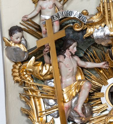 Zdjęcie nr 11: Nastawa ołtarzowa architektoniczna, trójosiowa z bramkami, jednokondygnacyjna ze zwieńczeniem. Ołtarz wysunięty do przodu, drewniany, sarkofagowy, wklęsło-wypukły, zwężający się ku dołowi, na profilowanym cokole, ujęty spływami wolutowymi; dekorowany w narożach palmetami, na froncie rocaille'owy kartusz z malowanymi skrzyżowanymi kluczami w polu. Mensa drewniana z silnie wysuniętą, profilowaną krawędzią, z portatylem z piaskowca. 

Tabernakulum w formie prostopadłościennej skrzynki o wypukłej ściance frontowej, ujęte z przodu ukośnie dostawionymi pilastrami na cokołach z trzonami w formie wolut, dźwigającymi niepełne belkowanie, opasujące je z trzech stron, nad ścianką frontową przyjmujące falistą formę zwieńczoną rocaille'm. Drzwiczki przyjmują kształt stojącego prostokąta zamkniętego łukiem półkolistym nadwieszonym, ujęte profilowaną ramą; w polu płaskorzeźbione przedstawienie kielicha z hostią w glorii na fakturowanym tle. Na belkowaniu, na osi podpór ustawiona jest para rocaille'owych lichtarzy. Tron wystawienia architektoniczny, trójosiowy; oś środkowa ponad tabernakulum w postaci ażurowej niszy z cokołem na pasyjkę, tylna ścianka utworzona z rocaille'u z kłosami zbóż; flankowana pilastrami zwieńczonymi falistym gzymsem, dźwigającymi ażurową, zamkniętą koronę. Podpory przechodzą w spływy wolutowe, ujmujące tabernakulum, na których końcach siedzi para adorujących puttów. Osie boczne są ujęte po bokach pilastrami dźwigającymi imposty podtrzymywane przez rocaille w partii trzonów oraz płonące wazony; pola wypełnione ażurowym rocaille'm i palmetami przechodzącymi w podwójne lichtarze.

Retabulum na planie półowalu, osie boczne ustawione prostopadle do środkowej. Oś środkowa posadowiona na wysokim, dwustrefowym cokole. W pierwszej strefie cokołu prostokątna płycina z napisem: „Z INICJATYWY / KS. PROBOSZCZA ROMANA GORCZYŃSKIEGO / W LATACH 2001 - 2006 / WYKONANO REMONT KOŚCIOŁA I KONSERWACJĘ / WYPOSAŻENIA”. W drugiej strefie cokołu, pośrodku płycina w formie leżącego prostokąta o fantazyjnie wyciętych bokach z malowanym kartuszem herbowym, dzielonym na cztery pola. W lewym górnym polu kartusza umieszczony jest orzeł, poniżej dwójka dzieci w łódce, a po prawej stronie tarczy, w prawym górnym polu dwójka dzieci w łódce, poniżej orzeł. U spodu napis z chronostychem: „EREXIT, AC EXORNAVIT HONORIBVS SANCTI PETRI, / AC PAVLI APOSTOLI ILLVSTRISSIMVS LIBER BAR I WNBS(?) IOANELLY / A TOLVANA PROPPII X I”. Klejnotem jest hełm z pióropuszem zakończony półpostacią rycerza w zbroi, zaś labry mają formę bujnej wici akantowej.  Ryzality cokołów ozdobione są z trzech stron rocaille'owymi płycinami; skrajne konsole rocaille'm i różanymi gałązkami. Oś główna flankowana parą kolumn ustawioną na tle zwielokrotnionych pilastrów. Podpory dźwigają pełne belkowanie, przerwane nad polem środkowym, wyłamane na ich osi oraz przerwany wolutowy przyczółek. W polu środkowym podwójna, profilowana rama w formie stojącego prostokąta zamkniętego łukiem nadwieszonym z uskokami z obrazem św. Piotra i św. Pawła; flankowana przez figury św. Szymona po lewej stronie i św. Judy Tadeusza po prawej, ustawionymi na rocaille'owych wspornikach. Ramy obrazu, trzony wewnętrznych pilastrów i pola za środkową parą figur dekorowane rocaille'm. 

Zwieńczenie w formie zbliżonej do stojącego prostokąta, ujęte spływami wolutowymi, zamknięte falistym gzymsem przechodzącym w antytetycznie zwrócone woluty. Całość zwieńczona gołębicą Ducha Świętego w glorii promienistej. W polu rzeźbiarska grupa Koronacji Marii w glorii promienistej, pośród obłoków i uskrzydlonych główek anielskich. Dwa flankujące grupę putta  na obłokach trzymają banderole z napisem: „FILIA DEI PATRIS” i „MATER DEI FILII”, a kolejne dwa usadzone na szczycie: „VENI CORONABERIS” oraz „VENI SPONSA MEA”. Poniżej zwieńczenia w ażurowym kartuszu znajduje się napis: „QVA E/ST ISTA / QVAE PROGREDI/TUR QVASI AURORA / CONSURGENS / Cant 6.”. Na przyczółku siedzące figury św. Joachima po lewej stronie i św. Józefa po prawej, na gzymsie flankującym pole środkowe dwa putta trzymające słońce i księżyc, na zewnętrznych osiach dwa adorujące anioły. Spływy zwieńczenia dekorowane strzępiastymi liśćmi palmowymi, muszlą i rocaille’m. 

Osie boczne ustawione są na wysokim cokole, od zewnątrz ujęte pilastrami przechodzącymi w woluty, od wewnątrz sąsiadują z osią środkową. Pośrodku bramki z drzwiczkami zakończonymi gzymsem przyjmującym formę cokołu dla figur. Drzwiczki w formie stojącego prostokątna zamkniętego łukiem segmentowym nadwieszonym; osie na skraju ujęte konsolami stanowiącymi cokoły dla podpór. Ryzalit bramek zdobiony płyciną ze strzępiastym grzebieniem; drzwiczki z płyciną z rocaille'm i kwiatowym zwisem na wstążce; powyższy cokół ujęty liśćmi palmowymi i rocaille'm. Kondygnacja flankowana na skraju kolumną ustawioną na tle pilastru, które podtrzymują wyłamany gzyms zakończony wolutami ujmującymi szczyt o falistym przebiegu, na którym ustawiony jest duży płomienisty wazon. W polach ustawione są figury: po lewej się Jakuba Starszego, a po prawej św. Filipa. Na zwieńczeniach usadzone dwie figury aniołów. 

Struktura w całości marmoryzowana w kolorze zielono-brązowym; ornamentyka, kolumny złocone, detale srebrzone. Wszystkie kolumny w jednej trzeciej wysokości przedzielone rocaille’m, a fryz z elementami dekoracji rokokowej. Tabernakulum i tron wystawienia w całości złocone.

