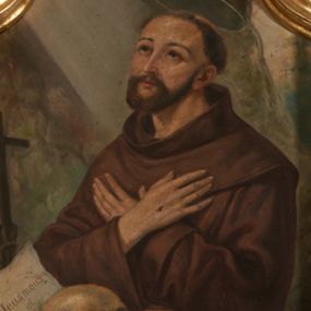 Zdjęcie nr 1: Obraz w kształcie stojącego prostokąta zamkniętego łukiem nadwieszonym z uskokiem. W centrum kompozycji ukazany w półpostaci, zwrócony w trzech czwartych w prawo św. Franciszek z Asyżu klęczący przed skałą, na której umieszczono krucyfiks, czaszkę, oraz kartkę z napisem „Deus meus / et / omnia”. Święty został przedstawiony jako dojrzały mężczyzna z krótką, brązową brodą, ubrany w brązowy habit, krzyżujący na wysokości piersi ręce z widocznymi stygmatami. Głowa z tonsurą uniesiona ku górze w stronę promieni przedstawionych w lewym, górnym narożu obrazu. Ponad głową widoczna aureola. W tle grota skalna. Kolorystyka obrazu ciemna, ciepła z dominacją brązów.