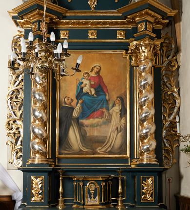 Zdjęcie nr 1: Ołtarz przyścienny, architektoniczny, dwukondygnacyjny, jednoosiowy. Mensa prostopadłościenna, antepedium haftowane w motyw kwiatowy z monogramem maryjnym. Na mensie architektoniczne, ujęte zdwojonymi, złoconymi kolumienkami tabernakulum z płaskorzeźbionym kielichem z hostią na drzwiczkach. W pierwszej kondygnacji obraz w kształcie stojącego prostokąta o uskokowo ściętych, górnych narożach z przedstawieniem Matki Boskiej Częstochowskiej oraz Matki Boskiej Różańcowej oraz św. Dominika i św. Katarzyny Sieneńskiej (na zasuwie). Kondygnacja ujęta umieszczonymi na postumentach, kręconymi, złoconymi  i srebrzonymi kolumnami o kompozytowych kapitelach ustawionymi na tle kanelowanych pilastrów. Podpory dźwigają pełne, wyłamane belkowanie zwieńczone wydatnym, profilowanym gzymsem. Na osiach podpór umieszczone pełnoplastyczne figury aniołów siedzących na obłokach. W drugiej kondygnacji obraz św. Antoniego Padewskiego w ramie zamkniętej łukiem półkolistym wyniesionym, z uskokiem. Szczyt w formie przerwanego przyczółka, na osi którego krzyż. Całość nastawy ujęta ażurowymi uszami uformowanymi z suchego akantu oraz wstęgi. Dekoracja akantowa, rozety, pola wypełnione kratą. Struktura nastawy w odcieniu ciemnej, morskiej zieleni, ornament złocony i srebrzony. Na portatylu nieczytelna odręczny napis z datą MDCCLXXII 1872.