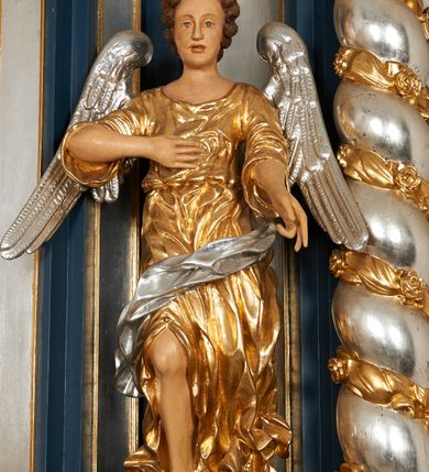 Zdjęcie nr 30: Ołtarz architektoniczny, trójosiowy, jednokondygnacyjny ze zwieńczeniem, na cokole. Mensa kamienna z portatylem. Antepedium proste, bez dekoracji, kamienne. Tabernakulum prostopadłościenne, ujęte pilastrami ustawionymi pod kątem, ze zwróconymi przeciwstawnie wolutami, zamiast trzonów, zwieńczone niepełnym belkowaniem. Drzwiczki w formie stojącego prostokąta zamkniętego łukiem półkolistym z krzyżem w polu. Retabulum ujęte parami pilastrów i kolumn o skręconych trzonach oraz kapitelach kompozytowych, dźwigających niepełne belkowanie z wydatnym gzymsem, wyłamanym w osiach podpór, przerwane w polu środkowym. Na gzymsie para puttów trzymających arma Christi. Osie boczne ustawione pod kątem względem lica ołtarza, w nich ustawiony dwie figury stojących aniołów. W polu środkowym ołtarza rama w formie stojącego prostokąta mieszcząca obraz św. Teresy z Lisieux. Zwieńczenie ołtarza w kształcie owalnego medalionu ujętego wydatnymi spływami wolutowymi. W polu owalny obraz przedstawiający wskrzeszenie Piotrowina. Kondygnacja pierwsza nastawy ujęta uszami utworzonymi z akantu. Cokoły podpór ozdobione z trzech stron płycinami z dekoracją roślinną w postaci liści i kwiatów. Na osi pilastrów cokoły podparte potrójną wolutą i parą girland owocowych. Trzony pilastrów i osie boczne dekorowane płycinami. Trzony kolumn zdobione ornamentem roślinnym. W polu środkowym ołtarza rama obrazu dekorowana akantem; u jej spodu akant i uskrzydlona główka anielska, zwieńczona akantem z palmetą. W zwieńczeniu profilowana rama dekorowana miejscami akantem, ujęta muszlą; woluty i lizeny zdobione kampanulami. Struktura ołtarza polichromowana na ciemnogranatowo ze złoconymi i srebrzonymi elementami architektonicznymi i ornamentyką.