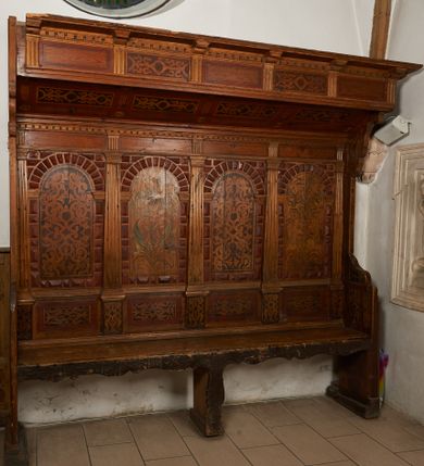 Zdjęcie nr 1: Stalle czterosiedzeniowe, z wysokim, czteroosiowym zapieckiem i baldachimem. Zaplecek artykułowany umieszczonymi na cokołach pilastrami o kanelowanych trzonach, dźwigającymi architraw z tryglifami na osi podpór oraz gzyms dekorowany kostkowaniem. W polach zaplecka arkady w boniowanym obramieniu. W arkadach malowana dekoracja, naprzemiennie stelaż okuciowy wypełniony ornamentem roślinnym oraz arabeska. W partii cokołów malowane płyciny z dekoracją geometryczno-roślinną. 
Baldachim uniesiony skośnie w górę, od spodu dekorowany malowanymi płycinami z okuciami; zakończony pełnym belkowaniem; fryz dekorowany tryglifami i malowanymi płycinami z okuciami; wydatny gzyms z kostkowaniem i konsolkami. Dekoracja w płycinach i dwóch zapleckach uzyskana na zasadzie malarstwa patronowego; wzór ugrowy na tle brunatnym; w pozostałych zapleckach arabeska w odcieniach zieleni i różu. Obramienia płycin i boniowanie polichromowane na czerwono.