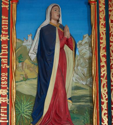 Zdjęcie nr 4: Ołtarz szafiasty, przyścienny, trójosiowy, jednokondygnacyjny ze zwieńczeniem. Mensa drewniana, prostopadłościenna. Antepedium z umieszczoną centralnie pseudopłyciną mieszczącą monogram IHS w akantowym otoku; boki zdobione, z lewej przedstawiony herb Łabędź. W części centralnej prostopadłościenne tabernakulum w formie kapliczki z ukośnie ustawionymi pilastrami zwieńczonymi pinaklami i kwiatonami. Predella u podstawy dekorowana fryzem palmetowym, wyżej pseudomaswerkowym, ostrołukowym ornamentem. Nastawa w formie tryptyku z neogotyckim, ażurowym zwieńczeniem zakończonym pinaklami i kwiatonem. Oś środkowa i osie boczne ujęte smukłymi, złoconymi kolumienkami o skręconych trzonach wspierającymi ażurową dekorację roślinną, w części centralnej uformowaną w kształt łuku w ośli grzbiet. W polu środkowym rzeźbiona scena Ukrzyżowania z figurą Chrystusa Ukrzyżowanego z klęczącą Marią Magdaleną obejmującą krzyż, umieszczona na tle górzystego pejzażu z widokiem Jerozolimy z lewej strony. W kwaterach bocznych, na tle pejzażu, płaskorzeźbione figury, po lewej stronie Maria na niewysokim postumencie z inskrypcją „S(ancta) Maria”, zwrócona w stronę krzyża; po prawej na postumencie z napisem „S(anctus) Johannes”, św. Jan Ewangelista trzymający kielich w lewej ręce. Wszystkie kwatery obwiedzione ramą ze złotą inskrypcją na czerwonym tle „Julianus de Skrzynno Dunin Brzeziński uxorque eius Eva cum matre sua Anastasia Morawska in honorem Dei Omnipotentis pro sua suorumque salute omniumque huius parochiae fidelium et prosperitiate et redemptione hoc jusferunt altare fieri A(nno) D(omini) 1892 salvo Leone XIII P(ontifice) M(aximo)”. Zwieńczenie ażurowe, płaskorzeźbione, w części centralnej powtarza kształt oślego grzbietu ze złoconym ornamentem stylizowanej wici roślinnej, w górnej części zamknięte pinaklami i kwiatonami. Kwatery boczne zwieńczone uszakami wypełnionymi ażurowym, złoconym suchym akantem, obwiedzione ornamentem ze stylizowanej wici roślinnej. Struktura malowana w odcieniu morskiej zieleni z czerwonymi detalami, ornamentyka złocona. Figury oraz tło kwater w pełni polichromowane.
