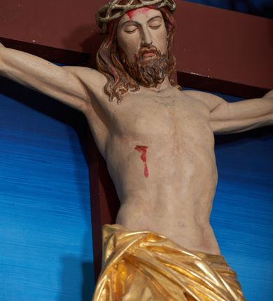 Zdjęcie nr 13: Ołtarz szafiasty, przyścienny, trójosiowy, jednokondygnacyjny ze zwieńczeniem. Mensa drewniana, prostopadłościenna. Antepedium z umieszczoną centralnie pseudopłyciną mieszczącą monogram IHS w akantowym otoku; boki zdobione, z lewej przedstawiony herb Łabędź. W części centralnej prostopadłościenne tabernakulum w formie kapliczki z ukośnie ustawionymi pilastrami zwieńczonymi pinaklami i kwiatonami. Predella u podstawy dekorowana fryzem palmetowym, wyżej pseudomaswerkowym, ostrołukowym ornamentem. Nastawa w formie tryptyku z neogotyckim, ażurowym zwieńczeniem zakończonym pinaklami i kwiatonem. Oś środkowa i osie boczne ujęte smukłymi, złoconymi kolumienkami o skręconych trzonach wspierającymi ażurową dekorację roślinną, w części centralnej uformowaną w kształt łuku w ośli grzbiet. W polu środkowym rzeźbiona scena Ukrzyżowania z figurą Chrystusa Ukrzyżowanego z klęczącą Marią Magdaleną obejmującą krzyż, umieszczona na tle górzystego pejzażu z widokiem Jerozolimy z lewej strony. W kwaterach bocznych, na tle pejzażu, płaskorzeźbione figury, po lewej stronie Maria na niewysokim postumencie z inskrypcją „S(ancta) Maria”, zwrócona w stronę krzyża; po prawej na postumencie z napisem „S(anctus) Johannes”, św. Jan Ewangelista trzymający kielich w lewej ręce. Wszystkie kwatery obwiedzione ramą ze złotą inskrypcją na czerwonym tle „Julianus de Skrzynno Dunin Brzeziński uxorque eius Eva cum matre sua Anastasia Morawska in honorem Dei Omnipotentis pro sua suorumque salute omniumque huius parochiae fidelium et prosperitiate et redemptione hoc jusferunt altare fieri A(nno) D(omini) 1892 salvo Leone XIII P(ontifice) M(aximo)”. Zwieńczenie ażurowe, płaskorzeźbione, w części centralnej powtarza kształt oślego grzbietu ze złoconym ornamentem stylizowanej wici roślinnej, w górnej części zamknięte pinaklami i kwiatonami. Kwatery boczne zwieńczone uszakami wypełnionymi ażurowym, złoconym suchym akantem, obwiedzione ornamentem ze stylizowanej wici roślinnej. Struktura malowana w odcieniu morskiej zieleni z czerwonymi detalami, ornamentyka złocona. Figury oraz tło kwater w pełni polichromowane.
