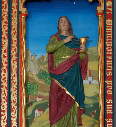 Zdjęcie nr 7: Ołtarz szafiasty, przyścienny, trójosiowy, jednokondygnacyjny ze zwieńczeniem. Mensa drewniana, prostopadłościenna. Antepedium z umieszczoną centralnie pseudopłyciną mieszczącą monogram IHS w akantowym otoku; boki zdobione, z lewej przedstawiony herb Łabędź. W części centralnej prostopadłościenne tabernakulum w formie kapliczki z ukośnie ustawionymi pilastrami zwieńczonymi pinaklami i kwiatonami. Predella u podstawy dekorowana fryzem palmetowym, wyżej pseudomaswerkowym, ostrołukowym ornamentem. Nastawa w formie tryptyku z neogotyckim, ażurowym zwieńczeniem zakończonym pinaklami i kwiatonem. Oś środkowa i osie boczne ujęte smukłymi, złoconymi kolumienkami o skręconych trzonach wspierającymi ażurową dekorację roślinną, w części centralnej uformowaną w kształt łuku w ośli grzbiet. W polu środkowym rzeźbiona scena Ukrzyżowania z figurą Chrystusa Ukrzyżowanego z klęczącą Marią Magdaleną obejmującą krzyż, umieszczona na tle górzystego pejzażu z widokiem Jerozolimy z lewej strony. W kwaterach bocznych, na tle pejzażu, płaskorzeźbione figury, po lewej stronie Maria na niewysokim postumencie z inskrypcją „S(ancta) Maria”, zwrócona w stronę krzyża; po prawej na postumencie z napisem „S(anctus) Johannes”, św. Jan Ewangelista trzymający kielich w lewej ręce. Wszystkie kwatery obwiedzione ramą ze złotą inskrypcją na czerwonym tle „Julianus de Skrzynno Dunin Brzeziński uxorque eius Eva cum matre sua Anastasia Morawska in honorem Dei Omnipotentis pro sua suorumque salute omniumque huius parochiae fidelium et prosperitiate et redemptione hoc jusferunt altare fieri A(nno) D(omini) 1892 salvo Leone XIII P(ontifice) M(aximo)”. Zwieńczenie ażurowe, płaskorzeźbione, w części centralnej powtarza kształt oślego grzbietu ze złoconym ornamentem stylizowanej wici roślinnej, w górnej części zamknięte pinaklami i kwiatonami. Kwatery boczne zwieńczone uszakami wypełnionymi ażurowym, złoconym suchym akantem, obwiedzione ornamentem ze stylizowanej wici roślinnej. Struktura malowana w odcieniu morskiej zieleni z czerwonymi detalami, ornamentyka złocona. Figury oraz tło kwater w pełni polichromowane.
