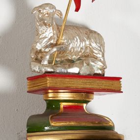 Zdjęcie nr 1: Pełnoplastyczna, wolnostojąca figura Baranka leżącego na zamkniętej księdze; z chorągwią pashalną. Całość umieszczona na wklęsło-wypukłym postumencie na planie odcinka koła. Postument i chorągiew polichromowane w kolorach czerwonym i zielonym oraz złocone, baranek srebrzony.