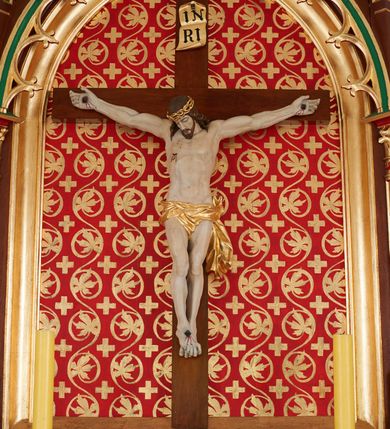 Zdjęcie nr 2: Ołtarz przyścienny, architektoniczny, jednokondygnacyjny, jednoosiowy. Mensa drewniana, prostopadłościenna na cokole. Antepedium dekorowane płyciną w formie leżącego prostokąta mieszczącą medalion z monogramem IHS w otoku z glorii promienistej. Retabulum o neogotyckich formach umieszczone na niewielkim cokole z monogramem PX na osi. W centrum ostrołukowa płycina ujęta złoconymi neogotyckimi kolumienkami mieszcząca rzeźbiony krucyfiks. W tle malowana dekoracja w postaci wici roślinnej oraz równoramiennych krzyży. Całość ujęta ażurowymi uszami w formie ostrołukowych, wypełnionych maswerkiem arkadek zwieńczonych pinaklami. Całość zamknięta od góry wimpergą zdobioną złoconymi żabkami oraz zwieńczoną krzyżem. Struktura malowana w odcieniach brązu, zieleni i czerwieni. Detal architektoniczny oraz ornamentyka złocone.