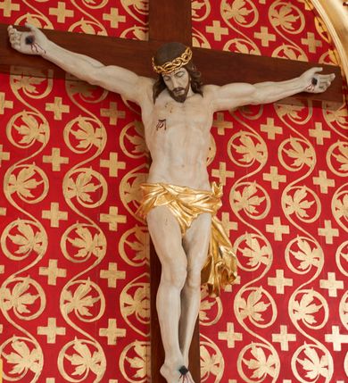 Zdjęcie nr 2: Pełnoplastyczna, polichromowana figura przedstawiająca ukrzyżowanego Chrystusa. Ciało muskularne o dobrze oddanej budowie anatomicznej z wyeksponowaną raną w prawym boku postaci. Głowa okolona długimi, brązowymi włosami, w cierniowej, złoconej koronie, opuszczona w dół i skierowana lekko w prawo. Twarz podłużna z zamkniętymi oczami, długim, prostym nosem oraz lekko rozchylonymi, sinymi ustami. Perizonium krótkie, złocone, udrapowane na lewym boku postaci. Stopy przebite jednym gwoździem. U szczytu pionowej belki krzyża złocony titulus z napisem „IN/RI”.