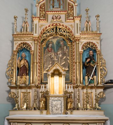 Zdjęcie nr 3: Rzeźba św. Pawła ustawiona na niskim prostopadłościennym cokole o ściętych narożach. Święty Paweł ustawiony frontalnie, w delikatnym kontrapoście, z lewą nogą ugiętą w kolanie. W prawej dłoni trzyma otwartą księgę, a w lewej miecz. Twarz o jasnej karnacji, z długim i szerokim nosem, okolona długą i bujną brodą. Włosy ciemnobrązowe, gęste, zaczesane do tyłu. Ubrany jest w zieloną suknię z długimi rękawami oraz ciemnobrązowy płaszcz ze złotą podszewką, zdobiony na brzegach złoconym pasem. Księga w czarnej obwolucie. Polichromia w odsłoniętych partiach ciała naturalistyczna, detale złocone i srebrzone.

