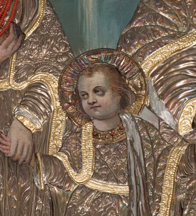 Zdjęcie nr 6: Obraz w kształcie stojącego prostokąta zamkniętego łukiem nadwieszonym, przedstawiająca Świętą Rodzinę. W centrum kompozycji mały Jezus trzyma za dłonie stojącego po prawej stronie obrazu św. Józefa oraz ukazaną po lewej stronie Matkę Boską. Postacie ukazane frontalnie, w postawie stojącej, Jezus z głową skierowaną w prawą stronę. Ponad nimi u góry nadlatująca gołębica Ducha Świętego. Maria przedstawiona jako młoda kobieta o pełnej, owalnej twarzy, okolonej długimi i falowanymi włosami. Prawą rękę wspiera na piersi, lewą trzyma za rękę Dzieciątko Jezus. Chrystus o pełnej, dziecięcej twarzy, okolonej jasnymi i krótkimi włosami. Święty Józef ukazany jako starszy mężczyzna z dłuższymi i siwymi włosami oraz krótką, gęstą brodą. Lewą rękę podtrzymuje rąbek szat, prawą trzyma za rękę Jezusa. Święty Józef oraz Matka Boska w koronach na głowie; wszystkie postacie w butach oraz długich i bogato drapowanych szatach przykrytych pozłacanymi sukienkami. W tle wypełniony roślinnością pejzaż oraz obłoki. Po lewej stronie św. Józefa gałązka białej lilii. Również na gołębicę Ducha Świętego nałożona srebrna sukienka. Kolorystyka chłodna, pociemniała. Rama drewniana, profilowana, złocona, zdobiona liśćmi stylizowanego akantu. 