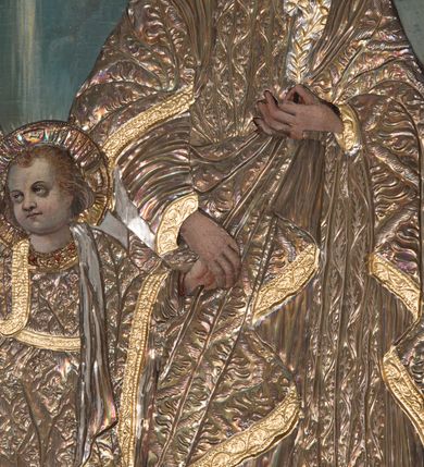 Zdjęcie nr 14: Ołtarz przyścienny, architektoniczny, trójosiowy z predellą i zwieńczeniem. Mensa prostopadłościenna, drewniana. Antepedium ujęte po bokach wysuniętymi przed lico lizenami z zakończonymi półokrągło płycinami. W polu o podziale architektonicznym – artykułowane złoconymi, kompozytowymi kolumienkami wspierającymi trójlistnie zakończone arkadki, w polu każdej dwie półkoliście zamknięte płyciny. Tabernakulum w formie prostopadłościennej skrzynki, flankowane ukośnie ustawionymi filarami wspierającymi profilowany gzyms. Drzwiczki wykonane z trybowanej, srebrzonej blachy; w polu środkowym z przedstawieniem głowy Chrystusa otoczonej gęstymi obłokami i promieniami, a dokoła ramą z wicią roślinną utworzoną z kiści winogron i kłosów zbóż. U spodu napis „TO JEST CIAŁO MOJE”. Na tabernakulum ustawiony jest tron wystawienia w formie prostopadłościennej aediculi, flankowany ukośnie ustawionymi kolumnami wspierającymi trójkątny szczyt. W polu prostokątna wnęka, zamknięta trójlistnie, o ściankach zdobionych motywem lilii heraldycznych. Po bokach tabernakulum ustawione dwie rzeźby klęczących aniołów.
Nastawa wsparta na wysokiej predelli, ujętej po bokach ażurowymi, akantowymi wolutami, pośrodku z dwiema lizenami wspierającymi podpory kondygnacji. W osiach predelli prostokątne płyciny, ozdobione w osiach bocznych rzeźbioną wicią roślinną. W polu środkowym kondygnacji głęboka, półkolista nisza mieszcząca obraz Świętej Rodziny, a na zasuwie obrazy Chrystusa Ukrzyżowanego i św. Józefa, obramowana płaskorzeźbioną ramą z liśćmi akantu; w podłuczu ażurowa akantowa dekoracja. Całość ujęta złoconymi kompozytowymi kolumnami, na których trzony w połowie wysokości nałożone są talerzyki. Kolumny dźwigają wysokie imposty oraz schodkowo przełamany gzyms. Ponad obrazem, w osi ołtarza znajdują się płaskorzeźbione główki anielskie o złoconych skrzydłach. Osie boczne o analogicznym układzie, arkady flankowane przez złocone kolumienki z figurami św. Piotra po lewej i św. Piotra po prawej stronie; zwieńczone pełnym belkowaniem – w partii fryzu symetryczny ornament o charakterze arabeskowym, gzyms dekorowany kimationem. Całość zwieńczona pinaklami zamkniętymi u góry złoconymi kwiatonami. Kondygnacja ujęta po bokach ażurowymi akantowymi uszami. Zwieńczenie flankowane złoconymi kolumienkami wspierającymi półkolistą arkadę oraz wyniesiony na osi szczyt ozdobiony pinaklami oraz w osi głównej krzyżem o trójlistnie zakończonych ramionach. W arkadzie ustawiona rzeźba Najświętszego Serca Pana Jezusa. Zwieńczenie ujęte po bokach ukształtowanymi w formę spływu uszami wypełnionymi płycinami z dekoracją akantową. Kolorystyka jasnobeżowa z elementami czerwieni, ornamenty i detale architektoniczne złocone.