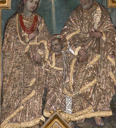 Zdjęcie nr 11: Ołtarz przyścienny, architektoniczny, trójosiowy z predellą i zwieńczeniem. Mensa prostopadłościenna, drewniana. Antepedium ujęte po bokach wysuniętymi przed lico lizenami z zakończonymi półokrągło płycinami. W polu o podziale architektonicznym – artykułowane złoconymi, kompozytowymi kolumienkami wspierającymi trójlistnie zakończone arkadki, w polu każdej dwie półkoliście zamknięte płyciny. Tabernakulum w formie prostopadłościennej skrzynki, flankowane ukośnie ustawionymi filarami wspierającymi profilowany gzyms. Drzwiczki wykonane z trybowanej, srebrzonej blachy; w polu środkowym z przedstawieniem głowy Chrystusa otoczonej gęstymi obłokami i promieniami, a dokoła ramą z wicią roślinną utworzoną z kiści winogron i kłosów zbóż. U spodu napis „TO JEST CIAŁO MOJE”. Na tabernakulum ustawiony jest tron wystawienia w formie prostopadłościennej aediculi, flankowany ukośnie ustawionymi kolumnami wspierającymi trójkątny szczyt. W polu prostokątna wnęka, zamknięta trójlistnie, o ściankach zdobionych motywem lilii heraldycznych. Po bokach tabernakulum ustawione dwie rzeźby klęczących aniołów.
Nastawa wsparta na wysokiej predelli, ujętej po bokach ażurowymi, akantowymi wolutami, pośrodku z dwiema lizenami wspierającymi podpory kondygnacji. W osiach predelli prostokątne płyciny, ozdobione w osiach bocznych rzeźbioną wicią roślinną. W polu środkowym kondygnacji głęboka, półkolista nisza mieszcząca obraz Świętej Rodziny, a na zasuwie obrazy Chrystusa Ukrzyżowanego i św. Józefa, obramowana płaskorzeźbioną ramą z liśćmi akantu; w podłuczu ażurowa akantowa dekoracja. Całość ujęta złoconymi kompozytowymi kolumnami, na których trzony w połowie wysokości nałożone są talerzyki. Kolumny dźwigają wysokie imposty oraz schodkowo przełamany gzyms. Ponad obrazem, w osi ołtarza znajdują się płaskorzeźbione główki anielskie o złoconych skrzydłach. Osie boczne o analogicznym układzie, arkady flankowane przez złocone kolumienki z figurami św. Piotra po lewej i św. Piotra po prawej stronie; zwieńczone pełnym belkowaniem – w partii fryzu symetryczny ornament o charakterze arabeskowym, gzyms dekorowany kimationem. Całość zwieńczona pinaklami zamkniętymi u góry złoconymi kwiatonami. Kondygnacja ujęta po bokach ażurowymi akantowymi uszami. Zwieńczenie flankowane złoconymi kolumienkami wspierającymi półkolistą arkadę oraz wyniesiony na osi szczyt ozdobiony pinaklami oraz w osi głównej krzyżem o trójlistnie zakończonych ramionach. W arkadzie ustawiona rzeźba Najświętszego Serca Pana Jezusa. Zwieńczenie ujęte po bokach ukształtowanymi w formę spływu uszami wypełnionymi płycinami z dekoracją akantową. Kolorystyka jasnobeżowa z elementami czerwieni, ornamenty i detale architektoniczne złocone.