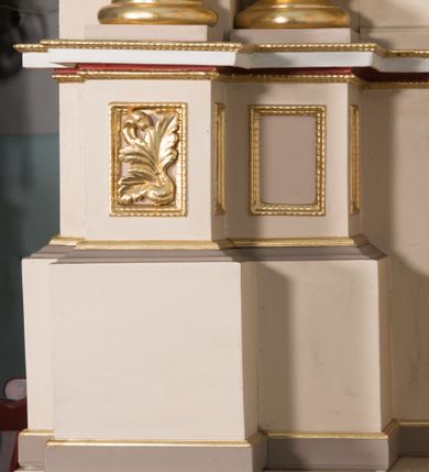 Zdjęcie nr 8: Nastawa ołtarzowa architektoniczna, jednoosiowa, jednokondygnacyjna ze zwieńczeniem. Ołtarz prostopadłościenny, drewniany; mensa drewniana. Antepedium w kształcie leżącego prostokąta ujętego profilowaną ramą; w polu płycina z malowaną i złoconą dekoracją roślinną flankującą medalion z krzyżem równoramiennym. Tabernakulum w formie prostopadłościennej skrzynki. Drzwiczki o kształcie stojącego prostokąta z płyciną dekorowaną malowanym i złoconym przedstawieniem kiści i liścia winnego grona oraz symetrycznego kłosa. Predella dekorowana płyciną z malowaną i złoconą dekoracją stylizowanego akantu. Nastawa ołtarzowa ustawiona na zdwojonym cokole, ujęta dwiema parami kolumn o kapitelach kompozytowych, z których zewnętrzna para wysunięta jest do przodu i ustawiona na tle filarów. Cokoły zdobione są płycinami o karbowanych ramach, na osi zewnętrznych podpór z płaskorzeźbionym liściem. Podpory dźwigają niepełne belkowanie składające się z fryzu i silnie wysuniętego gzymsu, wyłamane na ich osi; nad polem środkowym połączone gzymsem oraz przerwany trójkątny przyczółek z siedzącą na nim parą aniołów. W polu znajduje się ozdobna rama w kształcie stojącego prostokąta, zamkniętego łukiem nadwieszonym z obrazem św. Antoniego Padewskiego z Matką Boską z Dzieciątkiem. Zwieńczenie w kształcie stojącego prostokąta, zamknięte łukiem półkolistym, ustawione na wysokim cokole, ujęte parą kolumn o kapitelach kompozytowych podtrzymujących przerwany przyczółek; po bokach flankowane spływami wolutowymi. U szczytu akroterion w formie neorokokowej dekoracji roślinnej. W polu obraz św. Franciszka przed Chrystusem w ramie powtarzającej kształt zwieńczenia. Struktura w całości polichromowana w kolorze jasnobeżowym; kolumny, ornamentyka i profile złocone.