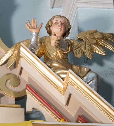 Zdjęcie nr 6: Nastawa ołtarzowa architektoniczna, jednoosiowa, jednokondygnacyjna ze zwieńczeniem. Ołtarz prostopadłościenny, drewniany; mensa drewniana. Antepedium w kształcie leżącego prostokąta ujętego profilowaną ramą; w polu płycina z malowaną i złoconą dekoracją roślinną flankującą medalion z krzyżem równoramiennym. Tabernakulum w formie prostopadłościennej skrzynki. Drzwiczki o kształcie stojącego prostokąta z płyciną dekorowaną malowanym i złoconym przedstawieniem kiści i liścia winnego grona oraz symetrycznego kłosa. Predella dekorowana płyciną z malowaną i złoconą dekoracją stylizowanego akantu. Nastawa ołtarzowa ustawiona na zdwojonym cokole, ujęta dwiema parami kolumn o kapitelach kompozytowych, z których zewnętrzna para wysunięta jest do przodu i ustawiona na tle filarów. Cokoły zdobione są płycinami o karbowanych ramach, na osi zewnętrznych podpór z płaskorzeźbionym liściem. Podpory dźwigają niepełne belkowanie składające się z fryzu i silnie wysuniętego gzymsu, wyłamane na ich osi; nad polem środkowym połączone gzymsem oraz przerwany trójkątny przyczółek z siedzącą na nim parą aniołów. W polu znajduje się ozdobna rama w kształcie stojącego prostokąta, zamkniętego łukiem nadwieszonym z obrazem św. Antoniego Padewskiego z Matką Boską z Dzieciątkiem. Zwieńczenie w kształcie stojącego prostokąta, zamknięte łukiem półkolistym, ustawione na wysokim cokole, ujęte parą kolumn o kapitelach kompozytowych podtrzymujących przerwany przyczółek; po bokach flankowane spływami wolutowymi. U szczytu akroterion w formie neorokokowej dekoracji roślinnej. W polu obraz św. Franciszka przed Chrystusem w ramie powtarzającej kształt zwieńczenia. Struktura w całości polichromowana w kolorze jasnobeżowym; kolumny, ornamentyka i profile złocone.