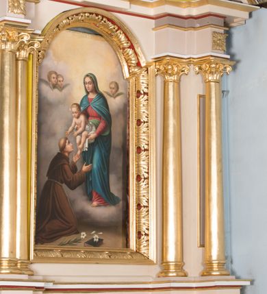 Zdjęcie nr 3: Nastawa ołtarzowa architektoniczna, jednoosiowa, jednokondygnacyjna ze zwieńczeniem. Ołtarz prostopadłościenny, drewniany; mensa drewniana. Antepedium w kształcie leżącego prostokąta ujętego profilowaną ramą; w polu płycina z malowaną i złoconą dekoracją roślinną flankującą medalion z krzyżem równoramiennym. Tabernakulum w formie prostopadłościennej skrzynki. Drzwiczki o kształcie stojącego prostokąta z płyciną dekorowaną malowanym i złoconym przedstawieniem kiści i liścia winnego grona oraz symetrycznego kłosa. Predella dekorowana płyciną z malowaną i złoconą dekoracją stylizowanego akantu. Nastawa ołtarzowa ustawiona na zdwojonym cokole, ujęta dwiema parami kolumn o kapitelach kompozytowych, z których zewnętrzna para wysunięta jest do przodu i ustawiona na tle filarów. Cokoły zdobione są płycinami o karbowanych ramach, na osi zewnętrznych podpór z płaskorzeźbionym liściem. Podpory dźwigają niepełne belkowanie składające się z fryzu i silnie wysuniętego gzymsu, wyłamane na ich osi; nad polem środkowym połączone gzymsem oraz przerwany trójkątny przyczółek z siedzącą na nim parą aniołów. W polu znajduje się ozdobna rama w kształcie stojącego prostokąta, zamkniętego łukiem nadwieszonym z obrazem św. Antoniego Padewskiego z Matką Boską z Dzieciątkiem. Zwieńczenie w kształcie stojącego prostokąta, zamknięte łukiem półkolistym, ustawione na wysokim cokole, ujęte parą kolumn o kapitelach kompozytowych podtrzymujących przerwany przyczółek; po bokach flankowane spływami wolutowymi. U szczytu akroterion w formie neorokokowej dekoracji roślinnej. W polu obraz św. Franciszka przed Chrystusem w ramie powtarzającej kształt zwieńczenia. Struktura w całości polichromowana w kolorze jasnobeżowym; kolumny, ornamentyka i profile złocone.