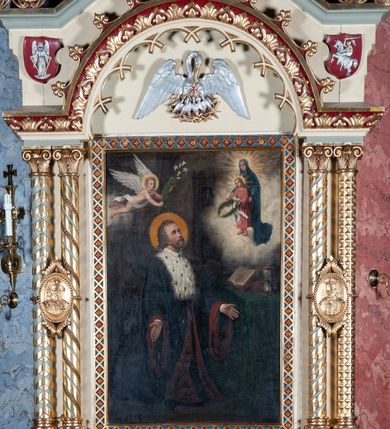 Zdjęcie nr 8: Obraz w formie stojącego prostokąta z przedstawieniem postaci św. Jana Kantego klęczącego przed stołem, ponad którym ukazuje się Matka Boska i młody Jezus. Święty zwrócony jest w trzech czwartych w lewo, ma rozłożone ręce i głowę uniesioną ku górze; wokół głowy nimb. Twarz owalna o starczych rysach, okolona siwą brodą. Włosy siwe, długie, opadają na kark. Święty jest ubrany w strój uniwersytecki w postaci czarnej togi z białym kołnierzykiem, podbitej czerwienią i gronostajowego mucetu. Ponad nim widoczny anioł w aureoli, przewiązany białą szarfą niosący białą lilię.  Powyżej, w prawym górnym rogu obrazu, w otoczeniu rozświetlonych chmur niewielka postać Matki Boskiej w niebieskim płaszczu, która prezentuje młodego Jezusa. Chrystus w różowej tunice trzyma w wysuniętych przed siebie dłoniach wieniec laurowy z białą wstęgą. Oboje mają wokół głów promieniste nimby. Przed świętym stoi stół przykryty zieloną tkaniną z dwiema księgami i klepsydrą. W tle widać fragment kolumny, sklepienia oraz regału z książkami. Malowidło w ciemnej tonacji, z zaakcentowanymi jasną kolorystyką dominantami kompozycyjnymi. Obraz ujęty ramą ze wzorem skośnej, złotej kratki o polach wypełnionych rozetami na czerwonym tle. 