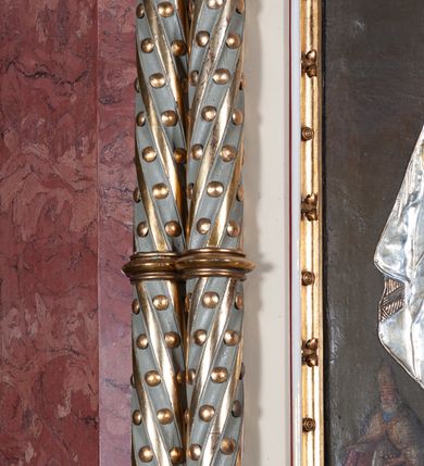 Zdjęcie nr 6: Ołtarz architektoniczny, jednokondygnacyjny, jednoosiowy, w formie aediculi, na podwójnym cokole oddzielonym linią gzymsu. Antepedium w formie leżącego prostokąta z trzema arkadami podtrzymywanymi przez kolumny toskańskie. Całość ujęta w dwie grube kolumny o kapitelach kompozytowych, stojące na cokołach. W narożach figury czterech istot apokaliptycznych: lwa, orła, anioła i wołu.  Pole środkowe nastawy flankowane jest dwiema parami kolumn na cokołach, o kapitelach kompozytowych. Wewnętrzna para kolumn została wysunięta nieco przed lico ołtarza i podtrzymuje półokrągłą arkadę. Całość zwieńczona gzymsem w formie łuku nadwieszonego, który w partii środkowej wyłamuje się, przybierając kształt prostokąta zwieńczonego trójkątnie. Cokoły dekorowane płycinami z ornamentem roślinnym, geometryczno-roślinnym i rozetami. Trzony kolumn kanelowane spiralnie, w połowie ujęte opaską, dekorowane guzami. Archiwolta arkady profilowana, ozdobiona maswerkiem. W polu środkowym obraz św. Mikołaja w profilowanej ramie z elementami geometrycznymi i liśćmi. W polu tympanonu płaskorzeźba z insygniami papieskimi – infułą, pastorałem, krzyżem patriarszym i kluczami. Powierzchnia ponad arkadą dekorowana kratką regencyjną z rozetami. Gzyms wieńczący ozdobiony rozetami i liśćmi oraz ażurowym akantem. Całość zwieńczona krzyżem. 
Struktura polichromowana na kolor kremowy, płyciny niebieskie i ciemnoczerwone, detale i ornamenty złocone i srebrzone. 
