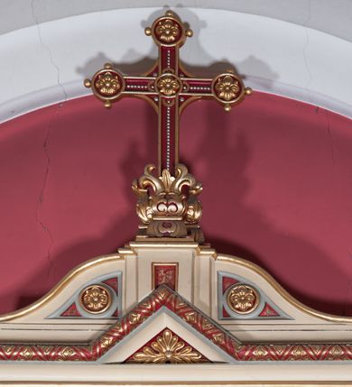 Zdjęcie nr 8: Nastawa ołtarzowa jednokondygnacyjna ze zwieńczeniem, trójosiowa, na cokole. Mensa prostopadłościenna, antepedium podzielone na cztery pola, wydzielone pięcioma kolumienkami, między nimi płyciny w kształcie stojących prostokątów zakończonych łukami półokrągłymi. Na mensie tron wystawienia w formie niszy ujęty parą smukłych kolumienek podtrzymujących szerokie belkowanie; w niszy krucyfiks. Cokół nastawy dekorowany prostokątami z imitacją marmoryzacji. Pierwsza kondygnacja utworzona z trzech arkad wydzielonych kolumnami, oś środkowa wyższa i szersza od bocznych. W polu środkowym figura Matki Boskiej Różańcowej w archiwolcie ujętej kolumienkami, w bocznych figury św. Dominika z lewej i św. Katarzyny Sieneńskiej z prawej strony. Poniżej cokołów postaci plakiety ornamentalne. Kolumny na zdwojonych cokołach, tak jak belkowanie powyżej wyłamane na ich osiach. Cokoły w dekorowane płycinami. Kondygnacja zamknięta belkowaniem przechodzącym w arkadę ponad polem centralnym, archiwolty dekorowane ornamentem roślinnym i geometrycznym. Zwieńczenie w formie leżącego prostokąta, tworzącego wysunięty szczyt, ponad którym krzyż łaciński na cokole ujętym spływami. Pola wypełniają rozety. 
Struktura polichromowana w kolorze kremowym; nisze niebieskie, płyciny i profilowania w kolorze czerwonym oraz szarym, elementy dekoracyjne złocone.
