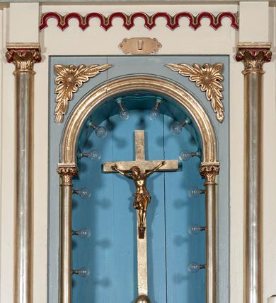 Zdjęcie nr 4: Nastawa ołtarzowa jednokondygnacyjna ze zwieńczeniem, trójosiowa, na cokole. Mensa prostopadłościenna, antepedium podzielone na cztery pola, wydzielone pięcioma kolumienkami, między nimi płyciny w kształcie stojących prostokątów zakończonych łukami półokrągłymi. Na mensie tron wystawienia w formie niszy ujęty parą smukłych kolumienek podtrzymujących szerokie belkowanie; w niszy krucyfiks. Cokół nastawy dekorowany prostokątami z imitacją marmoryzacji. Pierwsza kondygnacja utworzona z trzech arkad wydzielonych kolumnami, oś środkowa wyższa i szersza od bocznych. W polu środkowym figura Matki Boskiej Różańcowej w archiwolcie ujętej kolumienkami, w bocznych figury św. Dominika z lewej i św. Katarzyny Sieneńskiej z prawej strony. Poniżej cokołów postaci plakiety ornamentalne. Kolumny na zdwojonych cokołach, tak jak belkowanie powyżej wyłamane na ich osiach. Cokoły w dekorowane płycinami. Kondygnacja zamknięta belkowaniem przechodzącym w arkadę ponad polem centralnym, archiwolty dekorowane ornamentem roślinnym i geometrycznym. Zwieńczenie w formie leżącego prostokąta, tworzącego wysunięty szczyt, ponad którym krzyż łaciński na cokole ujętym spływami. Pola wypełniają rozety. 
Struktura polichromowana w kolorze kremowym; nisze niebieskie, płyciny i profilowania w kolorze czerwonym oraz szarym, elementy dekoracyjne złocone.
