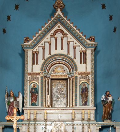 Zdjęcie nr 1: Ołtarz architektoniczny, jednokondygnacyjny, trójosiowy ze zwieńczeniem i bramkami, ustawiony na cokole. Mensa marmurowa z portatylem. Antepedium w formie wydłużonego, leżącego prostokąta. Ujęte w profilowaną ramę, podzielone na trzy części. Partia środkowa kwadratowa, w niej medalion z płaskorzeźbionym przedstawieniem gorejącego serca na tle skrzyżowanego krzyża i kotwicy. W partiach bocznych płaskorzeźbiony motyw maswerku. Na mensie prostopadłościenne tabernakulum z drzwiczkami dekorowanymi motywem silnie stylizowanych winnych gron, ustawione na cokole przerywanym trzema plakietami roślinnymi. Tabernakulum z dwóch stron podtrzymują stylizowane anioły. Pole środkowe nastawy ołtarza w formie uskokowego portalu zamkniętego półokrągłym łukiem z tympanonem. Dwie wewnętrzne archiwolty podtrzymywane przez półkolumny z kapitelami kompozytowymi, zewnętrzna przez pilastry. Portal flankują dwie nisze, zwieńczone łukiem nadwieszonym. Pierwszą kondygnację zamyka pas fryzu. W polu zwieńczenia ponad łukiem portalu rozchodzi się stopniowo pięć par kolumn o kostkowych kapitelach, które w partii wieńczącej podtrzymują profilowany łuk nadwieszony. Zwieńczenie zamknięte trójkątną linią belkowania, z pasem stopniowo spływających wolut, zakończone krzyżem. Cokół dekorowany płycinami z perełkowaniem, zakończony gzymsem z motywem wolich oczu. Poszczególne elementy niszy dekorowane różnorodnym ornamentem o charakterze geometryczno-roślinnym. W polu środkowym obraz Matki Boskiej z Dzieciątkiem w srebrnej sukience (Matki Boskiej Lisieckiej). W tympanonie płaskorzeźbione przedstawienie imienia Boga ujętego w trójkąt w glorii promienistej, w otoczeniu putt pośród obłoków. Nisze flankujące portal zwieńczone są płaskorzeźbionymi przedstawieniami centralnych świątyń kopułowych. W niszach płaskorzeźby św. Piotra po lewej i św. Pawła po prawej stronie. Fryz zamykający kondygnację z motywem palmet, w miejscu przecięcia z opaską portalu – uskrzydlone główki anielskie. W partii zwieńczenia, w przestrzeniach ponad kolumnami rozety. Ostatnia para kolumn ujęta w pionowe pasy imitujące zwinięty sznur. Łuk nadwieszony dekorowany ornamentem roślinnym. Cały ołtarz ujęty w pasy z dekoracją roślinną i motywem sznura. Wieńczące belkowanie z dekoracją geometryczną i rozetami, ujęte w woluty z mięsistego akantu. Podstawę dla krzyża tworzy akant z motywem palmety i perełkowania. Ołtarz flankują dwie bramki, na których stoją figury św. Michała Archanioła po lewej i św. Józefa po prawej stronie. 
Struktura w kolorze naturalnego kamienia – kremowa, profile w odcieniach niebieskiego, detale i ornamenty złocone. 
