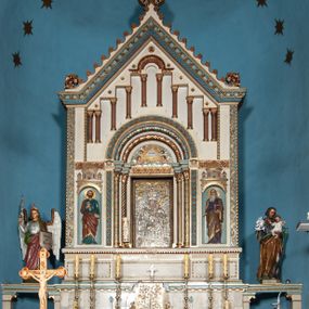 Zdjęcie nr 1: Ołtarz architektoniczny, jednokondygnacyjny, trójosiowy ze zwieńczeniem i bramkami, ustawiony na cokole. Mensa marmurowa z portatylem. Antepedium w formie wydłużonego, leżącego prostokąta. Ujęte w profilowaną ramę, podzielone na trzy części. Partia środkowa kwadratowa, w niej medalion z płaskorzeźbionym przedstawieniem gorejącego serca na tle skrzyżowanego krzyża i kotwicy. W partiach bocznych płaskorzeźbiony motyw maswerku. Na mensie prostopadłościenne tabernakulum z drzwiczkami dekorowanymi motywem silnie stylizowanych winnych gron, ustawione na cokole przerywanym trzema plakietami roślinnymi. Tabernakulum z dwóch stron podtrzymują stylizowane anioły. Pole środkowe nastawy ołtarza w formie uskokowego portalu zamkniętego półokrągłym łukiem z tympanonem. Dwie wewnętrzne archiwolty podtrzymywane przez półkolumny z kapitelami kompozytowymi, zewnętrzna przez pilastry. Portal flankują dwie nisze, zwieńczone łukiem nadwieszonym. Pierwszą kondygnację zamyka pas fryzu. W polu zwieńczenia ponad łukiem portalu rozchodzi się stopniowo pięć par kolumn o kostkowych kapitelach, które w partii wieńczącej podtrzymują profilowany łuk nadwieszony. Zwieńczenie zamknięte trójkątną linią belkowania, z pasem stopniowo spływających wolut, zakończone krzyżem. Cokół dekorowany płycinami z perełkowaniem, zakończony gzymsem z motywem wolich oczu. Poszczególne elementy niszy dekorowane różnorodnym ornamentem o charakterze geometryczno-roślinnym. W polu środkowym obraz Matki Boskiej z Dzieciątkiem w srebrnej sukience (Matki Boskiej Lisieckiej). W tympanonie płaskorzeźbione przedstawienie imienia Boga ujętego w trójkąt w glorii promienistej, w otoczeniu putt pośród obłoków. Nisze flankujące portal zwieńczone są płaskorzeźbionymi przedstawieniami centralnych świątyń kopułowych. W niszach płaskorzeźby św. Piotra po lewej i św. Pawła po prawej stronie. Fryz zamykający kondygnację z motywem palmet, w miejscu przecięcia z opaską portalu – uskrzydlone główki anielskie. W partii zwieńczenia, w przestrzeniach ponad kolumnami rozety. Ostatnia para kolumn ujęta w pionowe pasy imitujące zwinięty sznur. Łuk nadwieszony dekorowany ornamentem roślinnym. Cały ołtarz ujęty w pasy z dekoracją roślinną i motywem sznura. Wieńczące belkowanie z dekoracją geometryczną i rozetami, ujęte w woluty z mięsistego akantu. Podstawę dla krzyża tworzy akant z motywem palmety i perełkowania. Ołtarz flankują dwie bramki, na których stoją figury św. Michała Archanioła po lewej i św. Józefa po prawej stronie. 
Struktura w kolorze naturalnego kamienia – kremowa, profile w odcieniach niebieskiego, detale i ornamenty złocone. 
