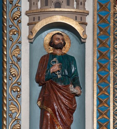 Zdjęcie nr 9: Ołtarz architektoniczny, jednokondygnacyjny, trójosiowy ze zwieńczeniem i bramkami, ustawiony na cokole. Mensa marmurowa z portatylem. Antepedium w formie wydłużonego, leżącego prostokąta. Ujęte w profilowaną ramę, podzielone na trzy części. Partia środkowa kwadratowa, w niej medalion z płaskorzeźbionym przedstawieniem gorejącego serca na tle skrzyżowanego krzyża i kotwicy. W partiach bocznych płaskorzeźbiony motyw maswerku. Na mensie prostopadłościenne tabernakulum z drzwiczkami dekorowanymi motywem silnie stylizowanych winnych gron, ustawione na cokole przerywanym trzema plakietami roślinnymi. Tabernakulum z dwóch stron podtrzymują stylizowane anioły. Pole środkowe nastawy ołtarza w formie uskokowego portalu zamkniętego półokrągłym łukiem z tympanonem. Dwie wewnętrzne archiwolty podtrzymywane przez półkolumny z kapitelami kompozytowymi, zewnętrzna przez pilastry. Portal flankują dwie nisze, zwieńczone łukiem nadwieszonym. Pierwszą kondygnację zamyka pas fryzu. W polu zwieńczenia ponad łukiem portalu rozchodzi się stopniowo pięć par kolumn o kostkowych kapitelach, które w partii wieńczącej podtrzymują profilowany łuk nadwieszony. Zwieńczenie zamknięte trójkątną linią belkowania, z pasem stopniowo spływających wolut, zakończone krzyżem. Cokół dekorowany płycinami z perełkowaniem, zakończony gzymsem z motywem wolich oczu. Poszczególne elementy niszy dekorowane różnorodnym ornamentem o charakterze geometryczno-roślinnym. W polu środkowym obraz Matki Boskiej z Dzieciątkiem w srebrnej sukience (Matki Boskiej Lisieckiej). W tympanonie płaskorzeźbione przedstawienie imienia Boga ujętego w trójkąt w glorii promienistej, w otoczeniu putt pośród obłoków. Nisze flankujące portal zwieńczone są płaskorzeźbionymi przedstawieniami centralnych świątyń kopułowych. W niszach płaskorzeźby św. Piotra po lewej i św. Pawła po prawej stronie. Fryz zamykający kondygnację z motywem palmet, w miejscu przecięcia z opaską portalu – uskrzydlone główki anielskie. W partii zwieńczenia, w przestrzeniach ponad kolumnami rozety. Ostatnia para kolumn ujęta w pionowe pasy imitujące zwinięty sznur. Łuk nadwieszony dekorowany ornamentem roślinnym. Cały ołtarz ujęty w pasy z dekoracją roślinną i motywem sznura. Wieńczące belkowanie z dekoracją geometryczną i rozetami, ujęte w woluty z mięsistego akantu. Podstawę dla krzyża tworzy akant z motywem palmety i perełkowania. Ołtarz flankują dwie bramki, na których stoją figury św. Michała Archanioła po lewej i św. Józefa po prawej stronie. 
Struktura w kolorze naturalnego kamienia – kremowa, profile w odcieniach niebieskiego, detale i ornamenty złocone. 
