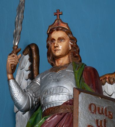 Zdjęcie nr 11: Ołtarz architektoniczny, jednokondygnacyjny, trójosiowy ze zwieńczeniem i bramkami, ustawiony na cokole. Mensa marmurowa z portatylem. Antepedium w formie wydłużonego, leżącego prostokąta. Ujęte w profilowaną ramę, podzielone na trzy części. Partia środkowa kwadratowa, w niej medalion z płaskorzeźbionym przedstawieniem gorejącego serca na tle skrzyżowanego krzyża i kotwicy. W partiach bocznych płaskorzeźbiony motyw maswerku. Na mensie prostopadłościenne tabernakulum z drzwiczkami dekorowanymi motywem silnie stylizowanych winnych gron, ustawione na cokole przerywanym trzema plakietami roślinnymi. Tabernakulum z dwóch stron podtrzymują stylizowane anioły. Pole środkowe nastawy ołtarza w formie uskokowego portalu zamkniętego półokrągłym łukiem z tympanonem. Dwie wewnętrzne archiwolty podtrzymywane przez półkolumny z kapitelami kompozytowymi, zewnętrzna przez pilastry. Portal flankują dwie nisze, zwieńczone łukiem nadwieszonym. Pierwszą kondygnację zamyka pas fryzu. W polu zwieńczenia ponad łukiem portalu rozchodzi się stopniowo pięć par kolumn o kostkowych kapitelach, które w partii wieńczącej podtrzymują profilowany łuk nadwieszony. Zwieńczenie zamknięte trójkątną linią belkowania, z pasem stopniowo spływających wolut, zakończone krzyżem. Cokół dekorowany płycinami z perełkowaniem, zakończony gzymsem z motywem wolich oczu. Poszczególne elementy niszy dekorowane różnorodnym ornamentem o charakterze geometryczno-roślinnym. W polu środkowym obraz Matki Boskiej z Dzieciątkiem w srebrnej sukience (Matki Boskiej Lisieckiej). W tympanonie płaskorzeźbione przedstawienie imienia Boga ujętego w trójkąt w glorii promienistej, w otoczeniu putt pośród obłoków. Nisze flankujące portal zwieńczone są płaskorzeźbionymi przedstawieniami centralnych świątyń kopułowych. W niszach płaskorzeźby św. Piotra po lewej i św. Pawła po prawej stronie. Fryz zamykający kondygnację z motywem palmet, w miejscu przecięcia z opaską portalu – uskrzydlone główki anielskie. W partii zwieńczenia, w przestrzeniach ponad kolumnami rozety. Ostatnia para kolumn ujęta w pionowe pasy imitujące zwinięty sznur. Łuk nadwieszony dekorowany ornamentem roślinnym. Cały ołtarz ujęty w pasy z dekoracją roślinną i motywem sznura. Wieńczące belkowanie z dekoracją geometryczną i rozetami, ujęte w woluty z mięsistego akantu. Podstawę dla krzyża tworzy akant z motywem palmety i perełkowania. Ołtarz flankują dwie bramki, na których stoją figury św. Michała Archanioła po lewej i św. Józefa po prawej stronie. 
Struktura w kolorze naturalnego kamienia – kremowa, profile w odcieniach niebieskiego, detale i ornamenty złocone. 
