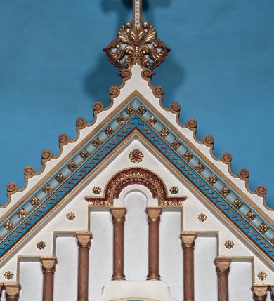 Zdjęcie nr 20: Ołtarz architektoniczny, jednokondygnacyjny, trójosiowy ze zwieńczeniem i bramkami, ustawiony na cokole. Mensa marmurowa z portatylem. Antepedium w formie wydłużonego, leżącego prostokąta. Ujęte w profilowaną ramę, podzielone na trzy części. Partia środkowa kwadratowa, w niej medalion z płaskorzeźbionym przedstawieniem gorejącego serca na tle skrzyżowanego krzyża i kotwicy. W partiach bocznych płaskorzeźbiony motyw maswerku. Na mensie prostopadłościenne tabernakulum z drzwiczkami dekorowanymi motywem silnie stylizowanych winnych gron, ustawione na cokole przerywanym trzema plakietami roślinnymi. Tabernakulum z dwóch stron podtrzymują stylizowane anioły. Pole środkowe nastawy ołtarza w formie uskokowego portalu zamkniętego półokrągłym łukiem z tympanonem. Dwie wewnętrzne archiwolty podtrzymywane przez półkolumny z kapitelami kompozytowymi, zewnętrzna przez pilastry. Portal flankują dwie nisze, zwieńczone łukiem nadwieszonym. Pierwszą kondygnację zamyka pas fryzu. W polu zwieńczenia ponad łukiem portalu rozchodzi się stopniowo pięć par kolumn o kostkowych kapitelach, które w partii wieńczącej podtrzymują profilowany łuk nadwieszony. Zwieńczenie zamknięte trójkątną linią belkowania, z pasem stopniowo spływających wolut, zakończone krzyżem. Cokół dekorowany płycinami z perełkowaniem, zakończony gzymsem z motywem wolich oczu. Poszczególne elementy niszy dekorowane różnorodnym ornamentem o charakterze geometryczno-roślinnym. W polu środkowym obraz Matki Boskiej z Dzieciątkiem w srebrnej sukience (Matki Boskiej Lisieckiej). W tympanonie płaskorzeźbione przedstawienie imienia Boga ujętego w trójkąt w glorii promienistej, w otoczeniu putt pośród obłoków. Nisze flankujące portal zwieńczone są płaskorzeźbionymi przedstawieniami centralnych świątyń kopułowych. W niszach płaskorzeźby św. Piotra po lewej i św. Pawła po prawej stronie. Fryz zamykający kondygnację z motywem palmet, w miejscu przecięcia z opaską portalu – uskrzydlone główki anielskie. W partii zwieńczenia, w przestrzeniach ponad kolumnami rozety. Ostatnia para kolumn ujęta w pionowe pasy imitujące zwinięty sznur. Łuk nadwieszony dekorowany ornamentem roślinnym. Cały ołtarz ujęty w pasy z dekoracją roślinną i motywem sznura. Wieńczące belkowanie z dekoracją geometryczną i rozetami, ujęte w woluty z mięsistego akantu. Podstawę dla krzyża tworzy akant z motywem palmety i perełkowania. Ołtarz flankują dwie bramki, na których stoją figury św. Michała Archanioła po lewej i św. Józefa po prawej stronie. 
Struktura w kolorze naturalnego kamienia – kremowa, profile w odcieniach niebieskiego, detale i ornamenty złocone. 
