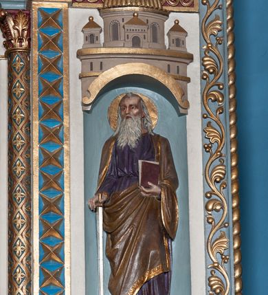 Zdjęcie nr 6: Ołtarz architektoniczny, jednokondygnacyjny, trójosiowy ze zwieńczeniem i bramkami, ustawiony na cokole. Mensa marmurowa z portatylem. Antepedium w formie wydłużonego, leżącego prostokąta. Ujęte w profilowaną ramę, podzielone na trzy części. Partia środkowa kwadratowa, w niej medalion z płaskorzeźbionym przedstawieniem gorejącego serca na tle skrzyżowanego krzyża i kotwicy. W partiach bocznych płaskorzeźbiony motyw maswerku. Na mensie prostopadłościenne tabernakulum z drzwiczkami dekorowanymi motywem silnie stylizowanych winnych gron, ustawione na cokole przerywanym trzema plakietami roślinnymi. Tabernakulum z dwóch stron podtrzymują stylizowane anioły. Pole środkowe nastawy ołtarza w formie uskokowego portalu zamkniętego półokrągłym łukiem z tympanonem. Dwie wewnętrzne archiwolty podtrzymywane przez półkolumny z kapitelami kompozytowymi, zewnętrzna przez pilastry. Portal flankują dwie nisze, zwieńczone łukiem nadwieszonym. Pierwszą kondygnację zamyka pas fryzu. W polu zwieńczenia ponad łukiem portalu rozchodzi się stopniowo pięć par kolumn o kostkowych kapitelach, które w partii wieńczącej podtrzymują profilowany łuk nadwieszony. Zwieńczenie zamknięte trójkątną linią belkowania, z pasem stopniowo spływających wolut, zakończone krzyżem. Cokół dekorowany płycinami z perełkowaniem, zakończony gzymsem z motywem wolich oczu. Poszczególne elementy niszy dekorowane różnorodnym ornamentem o charakterze geometryczno-roślinnym. W polu środkowym obraz Matki Boskiej z Dzieciątkiem w srebrnej sukience (Matki Boskiej Lisieckiej). W tympanonie płaskorzeźbione przedstawienie imienia Boga ujętego w trójkąt w glorii promienistej, w otoczeniu putt pośród obłoków. Nisze flankujące portal zwieńczone są płaskorzeźbionymi przedstawieniami centralnych świątyń kopułowych. W niszach płaskorzeźby św. Piotra po lewej i św. Pawła po prawej stronie. Fryz zamykający kondygnację z motywem palmet, w miejscu przecięcia z opaską portalu – uskrzydlone główki anielskie. W partii zwieńczenia, w przestrzeniach ponad kolumnami rozety. Ostatnia para kolumn ujęta w pionowe pasy imitujące zwinięty sznur. Łuk nadwieszony dekorowany ornamentem roślinnym. Cały ołtarz ujęty w pasy z dekoracją roślinną i motywem sznura. Wieńczące belkowanie z dekoracją geometryczną i rozetami, ujęte w woluty z mięsistego akantu. Podstawę dla krzyża tworzy akant z motywem palmety i perełkowania. Ołtarz flankują dwie bramki, na których stoją figury św. Michała Archanioła po lewej i św. Józefa po prawej stronie. 
Struktura w kolorze naturalnego kamienia – kremowa, profile w odcieniach niebieskiego, detale i ornamenty złocone. 
