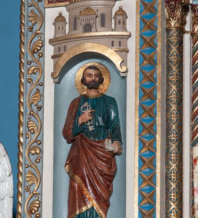 Zdjęcie nr 8: Ołtarz architektoniczny, jednokondygnacyjny, trójosiowy ze zwieńczeniem i bramkami, ustawiony na cokole. Mensa marmurowa z portatylem. Antepedium w formie wydłużonego, leżącego prostokąta. Ujęte w profilowaną ramę, podzielone na trzy części. Partia środkowa kwadratowa, w niej medalion z płaskorzeźbionym przedstawieniem gorejącego serca na tle skrzyżowanego krzyża i kotwicy. W partiach bocznych płaskorzeźbiony motyw maswerku. Na mensie prostopadłościenne tabernakulum z drzwiczkami dekorowanymi motywem silnie stylizowanych winnych gron, ustawione na cokole przerywanym trzema plakietami roślinnymi. Tabernakulum z dwóch stron podtrzymują stylizowane anioły. Pole środkowe nastawy ołtarza w formie uskokowego portalu zamkniętego półokrągłym łukiem z tympanonem. Dwie wewnętrzne archiwolty podtrzymywane przez półkolumny z kapitelami kompozytowymi, zewnętrzna przez pilastry. Portal flankują dwie nisze, zwieńczone łukiem nadwieszonym. Pierwszą kondygnację zamyka pas fryzu. W polu zwieńczenia ponad łukiem portalu rozchodzi się stopniowo pięć par kolumn o kostkowych kapitelach, które w partii wieńczącej podtrzymują profilowany łuk nadwieszony. Zwieńczenie zamknięte trójkątną linią belkowania, z pasem stopniowo spływających wolut, zakończone krzyżem. Cokół dekorowany płycinami z perełkowaniem, zakończony gzymsem z motywem wolich oczu. Poszczególne elementy niszy dekorowane różnorodnym ornamentem o charakterze geometryczno-roślinnym. W polu środkowym obraz Matki Boskiej z Dzieciątkiem w srebrnej sukience (Matki Boskiej Lisieckiej). W tympanonie płaskorzeźbione przedstawienie imienia Boga ujętego w trójkąt w glorii promienistej, w otoczeniu putt pośród obłoków. Nisze flankujące portal zwieńczone są płaskorzeźbionymi przedstawieniami centralnych świątyń kopułowych. W niszach płaskorzeźby św. Piotra po lewej i św. Pawła po prawej stronie. Fryz zamykający kondygnację z motywem palmet, w miejscu przecięcia z opaską portalu – uskrzydlone główki anielskie. W partii zwieńczenia, w przestrzeniach ponad kolumnami rozety. Ostatnia para kolumn ujęta w pionowe pasy imitujące zwinięty sznur. Łuk nadwieszony dekorowany ornamentem roślinnym. Cały ołtarz ujęty w pasy z dekoracją roślinną i motywem sznura. Wieńczące belkowanie z dekoracją geometryczną i rozetami, ujęte w woluty z mięsistego akantu. Podstawę dla krzyża tworzy akant z motywem palmety i perełkowania. Ołtarz flankują dwie bramki, na których stoją figury św. Michała Archanioła po lewej i św. Józefa po prawej stronie. 
Struktura w kolorze naturalnego kamienia – kremowa, profile w odcieniach niebieskiego, detale i ornamenty złocone. 
