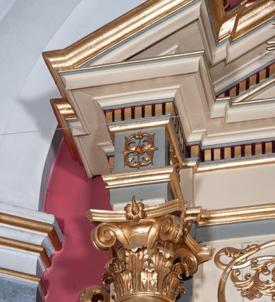 Zdjęcie nr 12: Ołtarz przyścienny, architektoniczny, jednoosiowy, jednokondygnacyjny, ze zwieńczeniem, na podwójnym cokole. Mensa w typie sarkofagowym; antepedium dekorowane monogramem IHS. Na mensie tabernakulum na rzucie zbliżonym do kwadratu, na profilowanej podstawie. Na licu drzwi w kształcie stojącego prostokąta zamkniętego łukiem półkolistym, ujęte kolumienkami, nad którymi gzyms i szczyt zamknięty łukiem nadwieszonym, wypełniony palmetą. Tabernakulum wieńczy krucyfiks. Oś środkowa nastawy flankowana parą kolumn o kapitelach kompozytowych, ustawionych przed licem ołtarza. Cokoły kolumn dekorowane płycinami z symetryczną dekoracją z wici. Podpory dźwigają pełne, wyłamane wielokrotnie belkowanie oraz odpowiadający ich ułożeniu wyłamany, trójkątny przyczółek. Na jego środku płaskorzeźba przedstawiająca gołębicę Ducha Świętego na tle obłoków i glorii. Między fryzem i gzumsem rząd kostkowania. W polu środkowym we wnęce w kształcie stojącego prostokąta zamkniętego łukiem półkolistym obraz Najświętszego Serca Jezusa w profilowanej ramie dekorowanej w kluczu i w połowie wysokości plakietami ornamentalnymi. W polach pod i nad obrazem wypełnienie z wici roślinnej, na fryzie belkowania kartusz z inskrypcją „SOLI DEO”. Kondygnację ujmują ażurowe uszaki utworzone z wici akantowej. Zwieńczenie w formie krzyża łacińskiego ustawionego na cokole ujętym wolutami. Struktura polichromowana na kremowo, fryzy i płyciny na szaro, detale, kolumny i ornamentyka złocone. 