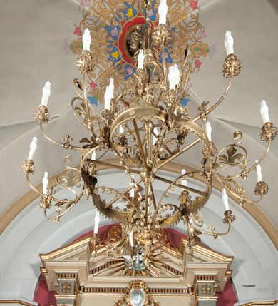 Zdjęcie nr 4: Ołtarz przyścienny, architektoniczny, jednoosiowy, jednokondygnacyjny, ze zwieńczeniem, na podwójnym cokole. Mensa w typie sarkofagowym; antepedium dekorowane monogramem IHS. Na mensie tabernakulum na rzucie zbliżonym do kwadratu, na profilowanej podstawie. Na licu drzwi w kształcie stojącego prostokąta zamkniętego łukiem półkolistym, ujęte kolumienkami, nad którymi gzyms i szczyt zamknięty łukiem nadwieszonym, wypełniony palmetą. Tabernakulum wieńczy krucyfiks. Oś środkowa nastawy flankowana parą kolumn o kapitelach kompozytowych, ustawionych przed licem ołtarza. Cokoły kolumn dekorowane płycinami z symetryczną dekoracją z wici. Podpory dźwigają pełne, wyłamane wielokrotnie belkowanie oraz odpowiadający ich ułożeniu wyłamany, trójkątny przyczółek. Na jego środku płaskorzeźba przedstawiająca gołębicę Ducha Świętego na tle obłoków i glorii. Między fryzem i gzumsem rząd kostkowania. W polu środkowym we wnęce w kształcie stojącego prostokąta zamkniętego łukiem półkolistym obraz Najświętszego Serca Jezusa w profilowanej ramie dekorowanej w kluczu i w połowie wysokości plakietami ornamentalnymi. W polach pod i nad obrazem wypełnienie z wici roślinnej, na fryzie belkowania kartusz z inskrypcją „SOLI DEO”. Kondygnację ujmują ażurowe uszaki utworzone z wici akantowej. Zwieńczenie w formie krzyża łacińskiego ustawionego na cokole ujętym wolutami. Struktura polichromowana na kremowo, fryzy i płyciny na szaro, detale, kolumny i ornamentyka złocone. 