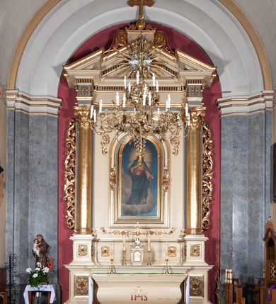 Zdjęcie nr 2: Ołtarz przyścienny, architektoniczny, jednoosiowy, jednokondygnacyjny, ze zwieńczeniem, na podwójnym cokole. Mensa w typie sarkofagowym; antepedium dekorowane monogramem IHS. Na mensie tabernakulum na rzucie zbliżonym do kwadratu, na profilowanej podstawie. Na licu drzwi w kształcie stojącego prostokąta zamkniętego łukiem półkolistym, ujęte kolumienkami, nad którymi gzyms i szczyt zamknięty łukiem nadwieszonym, wypełniony palmetą. Tabernakulum wieńczy krucyfiks. Oś środkowa nastawy flankowana parą kolumn o kapitelach kompozytowych, ustawionych przed licem ołtarza. Cokoły kolumn dekorowane płycinami z symetryczną dekoracją z wici. Podpory dźwigają pełne, wyłamane wielokrotnie belkowanie oraz odpowiadający ich ułożeniu wyłamany, trójkątny przyczółek. Na jego środku płaskorzeźba przedstawiająca gołębicę Ducha Świętego na tle obłoków i glorii. Między fryzem i gzumsem rząd kostkowania. W polu środkowym we wnęce w kształcie stojącego prostokąta zamkniętego łukiem półkolistym obraz Najświętszego Serca Jezusa w profilowanej ramie dekorowanej w kluczu i w połowie wysokości plakietami ornamentalnymi. W polach pod i nad obrazem wypełnienie z wici roślinnej, na fryzie belkowania kartusz z inskrypcją „SOLI DEO”. Kondygnację ujmują ażurowe uszaki utworzone z wici akantowej. Zwieńczenie w formie krzyża łacińskiego ustawionego na cokole ujętym wolutami. Struktura polichromowana na kremowo, fryzy i płyciny na szaro, detale, kolumny i ornamentyka złocone. 