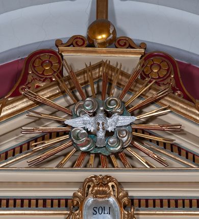 Zdjęcie nr 8: Ołtarz przyścienny, architektoniczny, jednoosiowy, jednokondygnacyjny, ze zwieńczeniem, na podwójnym cokole. Mensa w typie sarkofagowym; antepedium dekorowane monogramem IHS. Na mensie tabernakulum na rzucie zbliżonym do kwadratu, na profilowanej podstawie. Na licu drzwi w kształcie stojącego prostokąta zamkniętego łukiem półkolistym, ujęte kolumienkami, nad którymi gzyms i szczyt zamknięty łukiem nadwieszonym, wypełniony palmetą. Tabernakulum wieńczy krucyfiks. Oś środkowa nastawy flankowana parą kolumn o kapitelach kompozytowych, ustawionych przed licem ołtarza. Cokoły kolumn dekorowane płycinami z symetryczną dekoracją z wici. Podpory dźwigają pełne, wyłamane wielokrotnie belkowanie oraz odpowiadający ich ułożeniu wyłamany, trójkątny przyczółek. Na jego środku płaskorzeźba przedstawiająca gołębicę Ducha Świętego na tle obłoków i glorii. Między fryzem i gzumsem rząd kostkowania. W polu środkowym we wnęce w kształcie stojącego prostokąta zamkniętego łukiem półkolistym obraz Najświętszego Serca Jezusa w profilowanej ramie dekorowanej w kluczu i w połowie wysokości plakietami ornamentalnymi. W polach pod i nad obrazem wypełnienie z wici roślinnej, na fryzie belkowania kartusz z inskrypcją „SOLI DEO”. Kondygnację ujmują ażurowe uszaki utworzone z wici akantowej. Zwieńczenie w formie krzyża łacińskiego ustawionego na cokole ujętym wolutami. Struktura polichromowana na kremowo, fryzy i płyciny na szaro, detale, kolumny i ornamentyka złocone. 