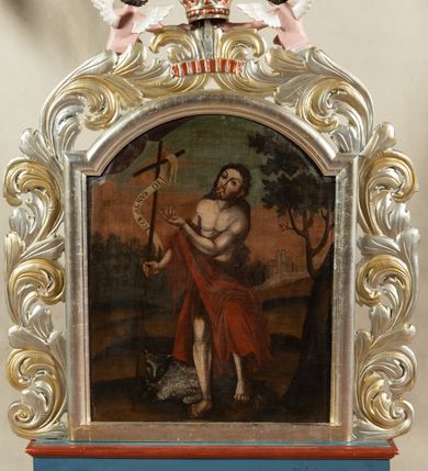 Zdjęcie nr 3: Feretron dwustronny, z podstawą prostopadłościenną, profilowaną, z otworami na drążki. Na podstawie obrazy z przedstawieniem Matki Boskiej z Dzieciątkiem oraz św. Jana Chrzciciela ujęte drewnianą ramą ze złoconej i srebrzonej wici akantowej spiętej u góry koroną trzymaną przez dwa putta. Matka Boska lewą ręką przytrzymuje Dzieciątko siedzące na jej lewej nodze, w prawej ręce trzyma berło. Ma podłużną twarz o półokrągłych, równych brwiach, ciemnych oczach, wąskim nosie, niewielkich ustach i zaznaczonych policzkach. Jest ubrana w czerwoną suknię i ziemnoszary płaszcz. Na głowie ma zamkniętą, kameryzowaną koronę przytrzymywaną przez dwa anioły w długich, czewrono-czarnych sukniach, trzymające kwiaty lilii. Dzieciątko ukazane frontalnie, prawą rączkę unosi w geście błogosławieństwa, w lewej trzyma kulę. Owalną twarz o ostrych rysach okalają pukle jasnobrązowych włosów. Dzieciątko  jest ubrane w cienką, białą sukienkę związaną pod szyją czerwoną wstążeczką. Tło obrazu jednolite, ciemnobrązowe.  
Z drugiej strony feretronu św. Jan Chrzciciel, ukazany w całej postaci, w wykroku na prawą nogę i głową przechyloną na lewe ramię. Prawą ręką trzyma długie drzewce zakończone krzyżem z przewiązaną banderolą z napisem „ECCE AGNUS DEI”, lewą unosi przed krzyżem. Ma szczupłą, owalną twarz z wąskim nosem i dużymi, ciemnymi oczami. Nosi wąsy i krótką brodę, a długie włosy spływają mu na plecy. Święty ma czerwony płaszcz przerzucony przez prawe przedramię, otaczający biodra i nogi. U jego stóp, po lewej stronie kompozycji leży baranek. Święty Jan został ukazany na tle pejzażu z drzewami i zabudowaniami. 
