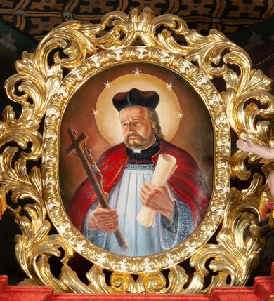 Zdjęcie nr 4: Ołtarz architektoniczny, jednokondygnacyjny, jednoosiowy, ze zwieńczeniem i drewnianą, sarkofagową mensą z kamiennym portatylem. Na mensie ołtarza kremowe tabernakulum w formie prostopadłościennej szafki, ujęte parą korynckich, złoconych półkolumienek, stojących na wyłamującym się, zdwojonym cokoliku, wspierających silnie wysunięty gzyms wieńczący. Drzwiczki w kształcie stojącego prostokąta, z prostokątną płyciną zwieńczoną łukiem półkolistym, zdobioną płaskorzeźbionym motywem kielicha, hostii, kłosów zboża i winnych gron.  Retabulum na cokole, ujęte parą pilastrów korynckich, z kanelurowaniem do połowy trzonu i parą filarów na tle których ustawiona jest para kolumn akantowych o spiralnie skręconych trzonach. Podpory wspierają wyłamujące się ponad nimi belkowanie o wysuniętym gzymsie. Zwieńczenie w formie stojącego owalu ujętego ażurową, akantową ramą, flankowane przerwanym, wklęsło wypukłym przyczółkiem. Dolne naroża antepedium zdobione motywem lwiej łapy ujętej parą wolut, z liściem akantu w zwieńczeniu. Pola cokołu, dolna partia pola środkowego i pola wewnątrz wnęki oraz fryz retabulum zdobiony motywem wici akantowej. Na trzonach kolumn retabulum spiralnie oplatająca je wić roślinna. Część środkowa retabulum ujęta parą ażurowych, akantowych uszaków. Pole środkowe w formie wnęki w kształcie stojącego prostokąta z przedstawieniem Najświętszego Serca Jezusa (druk) i obrazem św. Józefa (XX w.) na zasuwie. W zwieńczeniu pole obrazowe w kształcie stojącego owalu z przedstawieniem św. Jana Nepomucena. Na gzymsie przyczółka para siedzących aniołków. Kolorystyka struktury ołtarza w odcieniach szarości i czerwieni; ornamentyka i fragmenty detali architektonicznych złocone.  