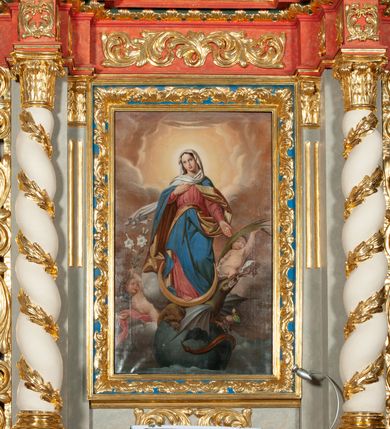 Zdjęcie nr 7: Ołtarz architektoniczny, jednokondygnacyjny, jednoosiowy, ze zwieńczeniem i drewnianą, sarkofagową mensą z kamiennym portatylem. Na mensie ołtarza kremowe tabernakulum w formie prostopadłościennej szafki, ujęte parą korynckich, złoconych półkolumienek, stojących na wyłamującym się, zdwojonym cokoliku, wspierających silnie wysunięty gzyms wieńczący. Drzwiczki w kształcie stojącego prostokąta, z prostokątną płyciną zwieńczoną łukiem półkolistym, zdobioną płaskorzeźbionym motywem kielicha, hostii, kłosów zboża i winnych gron.  Retabulum na cokole, ujęte parą pilastrów korynckich, z kanelurowaniem do połowy trzonu i parą filarów, na tle których ustawiona jest para kolumn akantowych o spiralnie skręconych trzonach. Podpory wspierają wyłamujące się ponad nimi belkowanie o wysuniętym gzymsie. Zwieńczenie w formie stojącego owalu ujętego ażurową, akantową ramą, flankowane przerwanym, wklęsło wypukłym przyczółkiem. Dolne naroża antepedium zdobione motywem lwiej łapy ujętej parą wolut, z liściem akantu w zwieńczeniu. Pola cokołu, dolna partia pola środkowego i pola wewnątrz wnęki, oraz fryz retabulum zdobiony motywem wici akantowej. Na trzonach kolumn retabulum spiralnie oplatająca ją wić roślinna. Cześć środkowa retabulum ujęta parą ażurowych, akantowych uszaków. Pole środkowe w formie wnęki w kształcie stojącego prostokąta z przedstawieniem Matki Boskiej Nieustającej Pomocy oraz Niepokalanego Poczęcia Najświętszej Marii Panny na zasuwie. W zwieńczeniu pole obrazowe w kształcie stojącego owalu z przedstawieniem Veraicon. Na gzymsie przyczółka para siedzących aniołków. Kolorystyka struktury ołtarza w odcieniach szarości i czerwieni; ornamentyka i fragmenty detali architektonicznych złocone.  