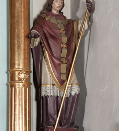 Zdjęcie nr 8: Nastawa architektoniczna, jednoosiowa, jednokondygnacyjna ze zwieńczeniem. Ołtarz drewniany, prostopadłościenny, z drewnianą mensą, ustawiony na profilowanym cokole. Ścianka frontowa ujęta pilastrami z płycinami w partii trzonów z akantem. W polu dwie płyciny o fantazyjnej formie wypełnione stylizowanym ornamentem akantowym, flankujące medalion z inicjałami „MS”. Ścianki boczne dekorowane płycinami. 
Na ołtarzu ustawione tabernakulum w formie drewnianej skrzynki, na cokole, flankowanej spływami wolutowymi, zwieńczonej szczytem zamkniętym łukowatym fragmentem gzymsu z płyciną i uskrzydloną główką anielską w polu. Drzwiczki w kształciestojącego prostokąta zamkniętego łukiem falistym, ujęte profilowaną ramą z przedstawieniem kielicha z hostią. 
Nastawa na cokole z wyodrębnionymi dwoma prostopadłościanami i dwoma skrajnymi konsolami, dekorowanym płycinami ze stylizowanym ornamentem. Retabulum ujęte parą kolumn o trzonach kanelowanych w jednej trzeciej wysokości, podtrzymujących belkowanie o architrawie i fryzie przerwanym nad polem środkowym. Na belkowaniu fragmenty przerwanego, półkolistego przyczółka z siedzącymi puttami. Niemal całe pole główne wypełnione wnęką w formie stojącego prostokąta zamkniętego łukiem półkolistym nadwieszonym, z uskokiem, w profilowanej ramie, z obrazami komunii anielskiej św. Stanisława Kostki i św. Józefa na zasuwie. Na konsolach, po bokach nastawy ustawione figury św. Wojciecha i św. Stanisława. Zwieńczenie w formie zbliżonej do stojącego prostokąta, ujętego spływami wolutowymi, zamkniętego dwiema stykającymi się wolutami oraz dwiema uskrzydlonymi główkami anielskimi w glorii promienistej. W polu obraz św. Rozalii w kształcie zbliżonym do zwieńczenia, ujęty profilowaną ramą. Struktura polichromowana w kolorze seledynowym, kolumny, profile i ornamentyka złocone. 


